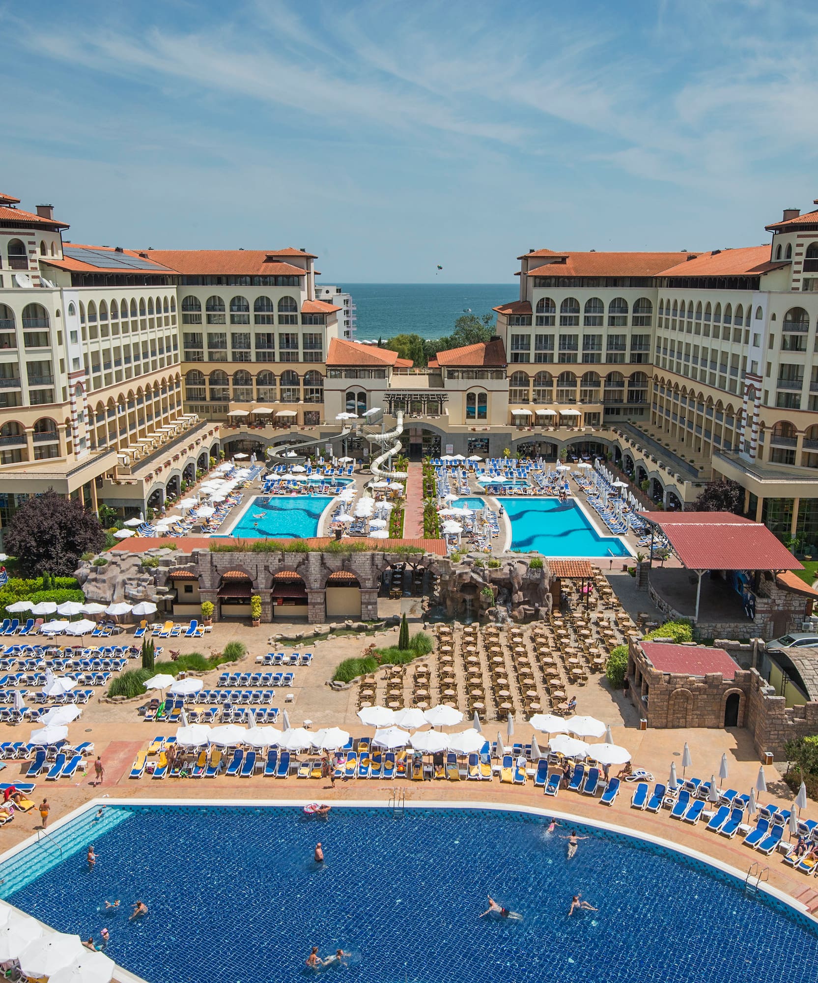 a swimming pool and a large building with many people
