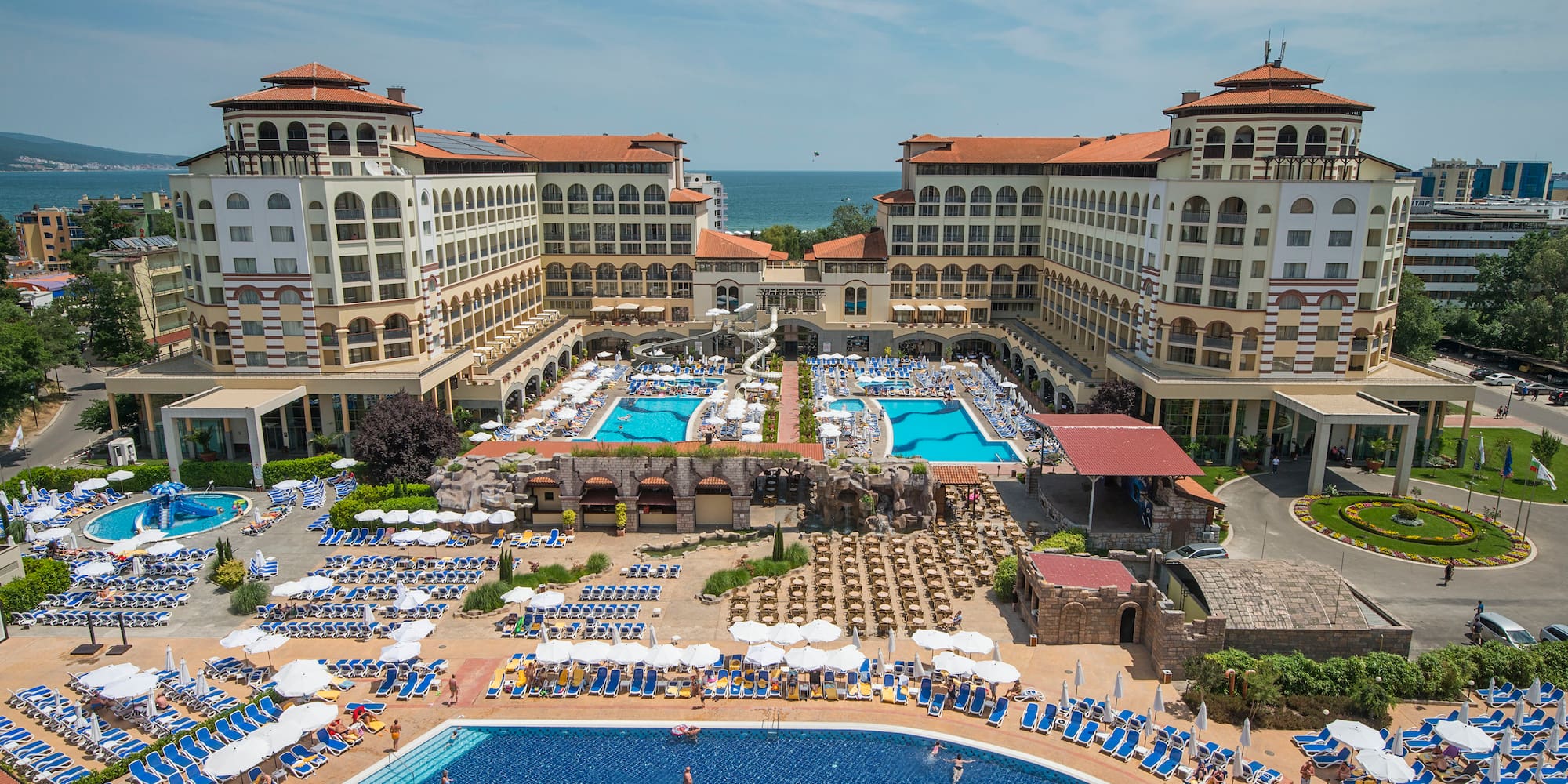 a swimming pool and a large building with many people