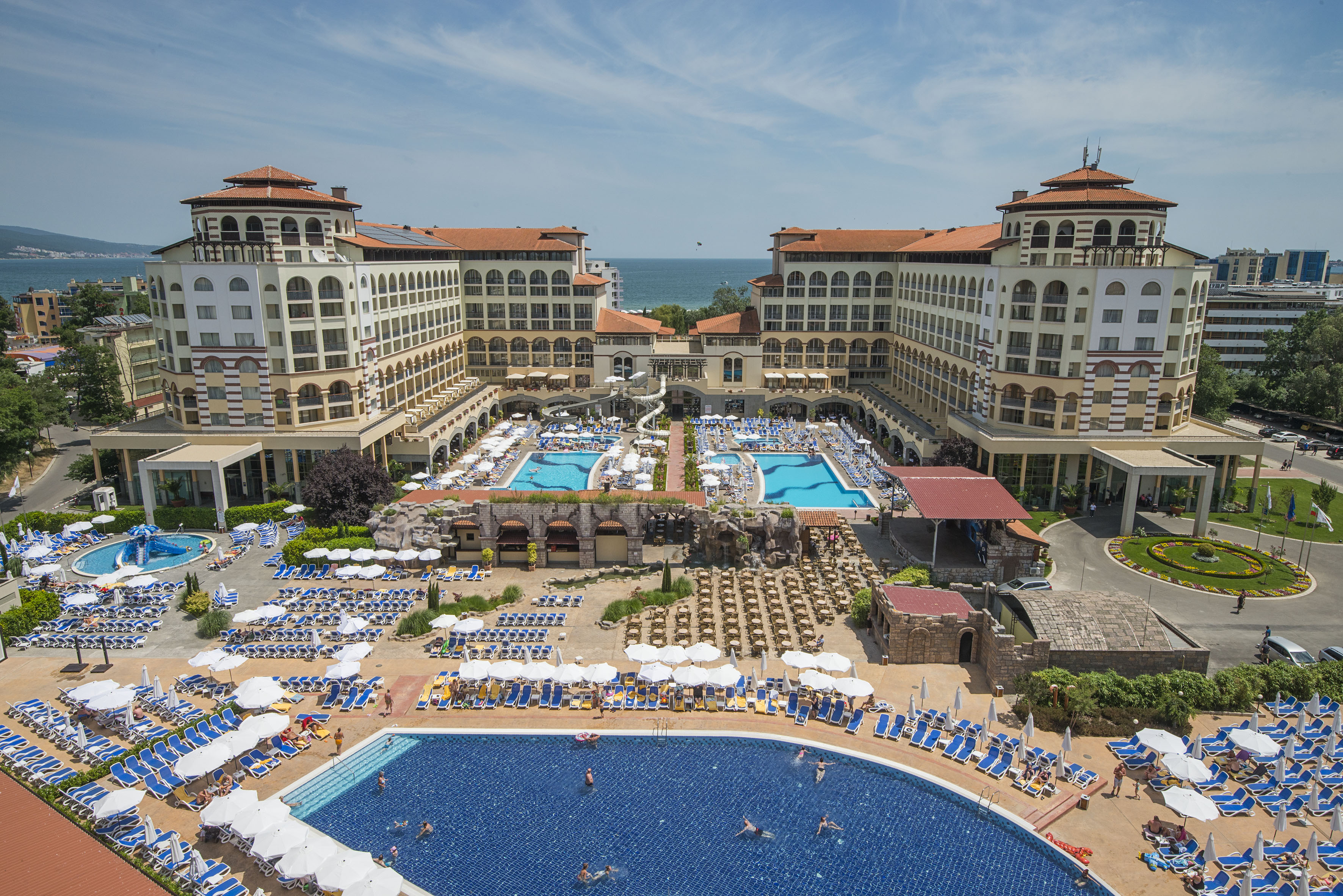 a swimming pool and a large building with many people