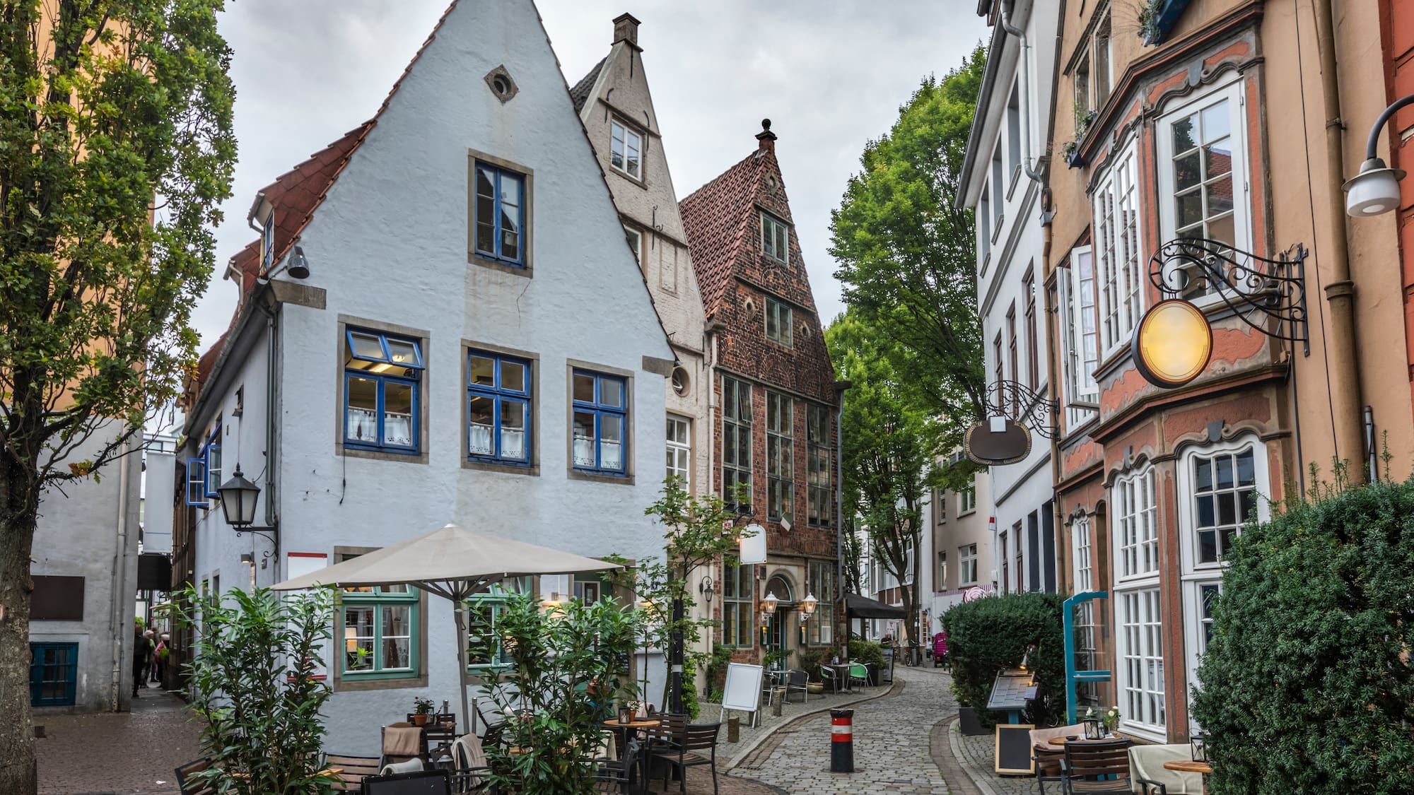 a street with buildings and tables and chairs