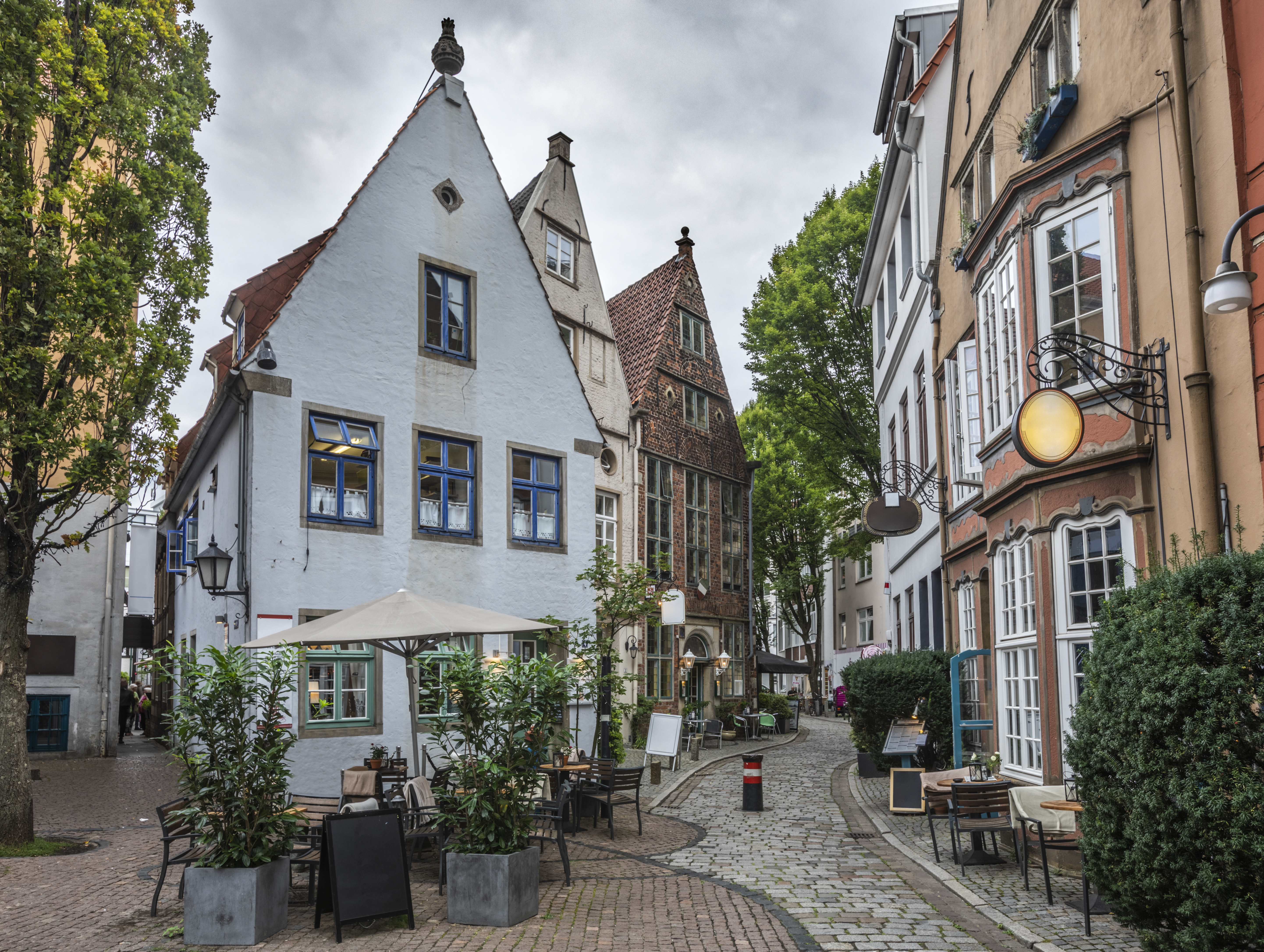 a street with buildings and tables and chairs