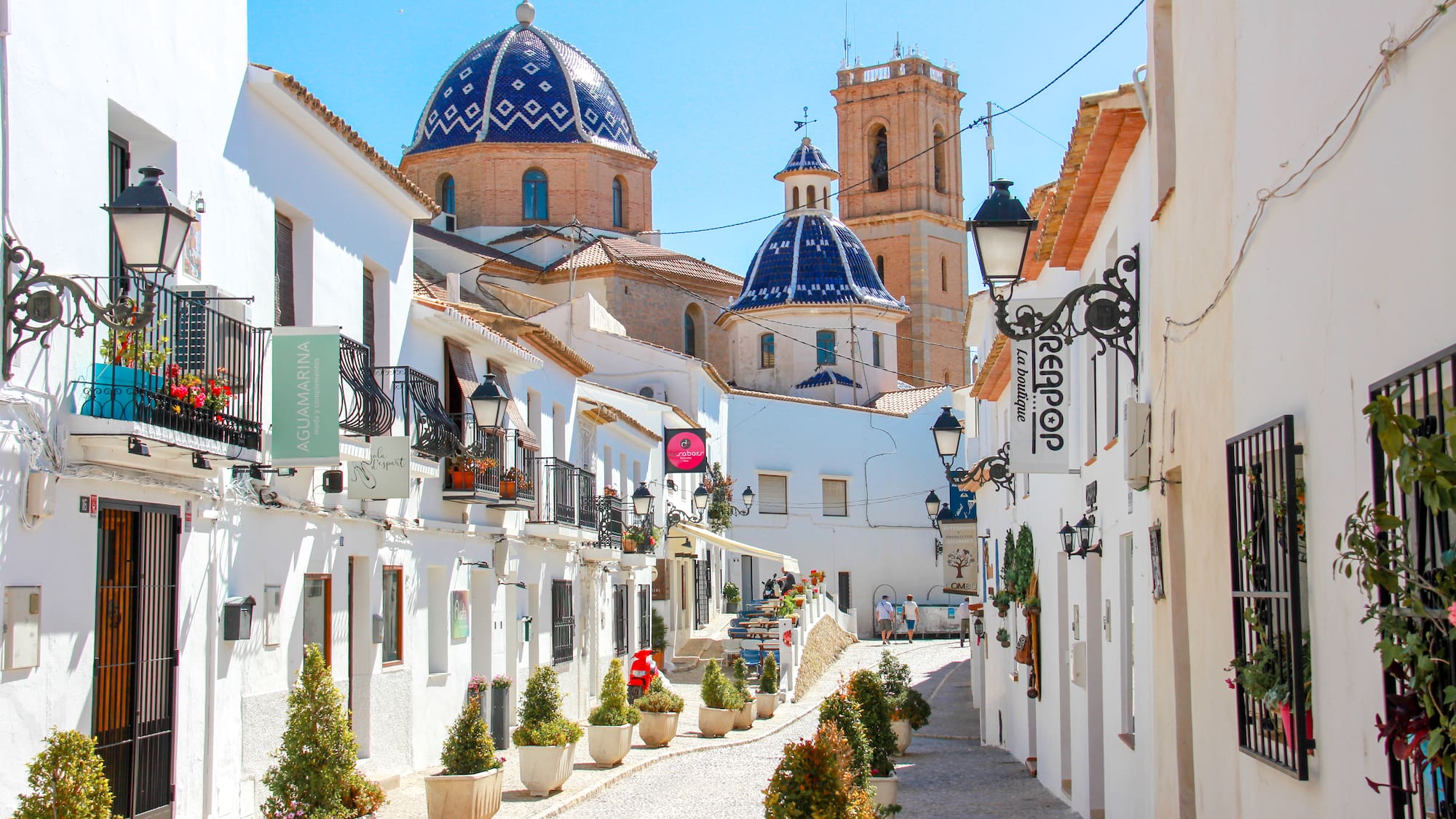 a street with white buildings and blue dome