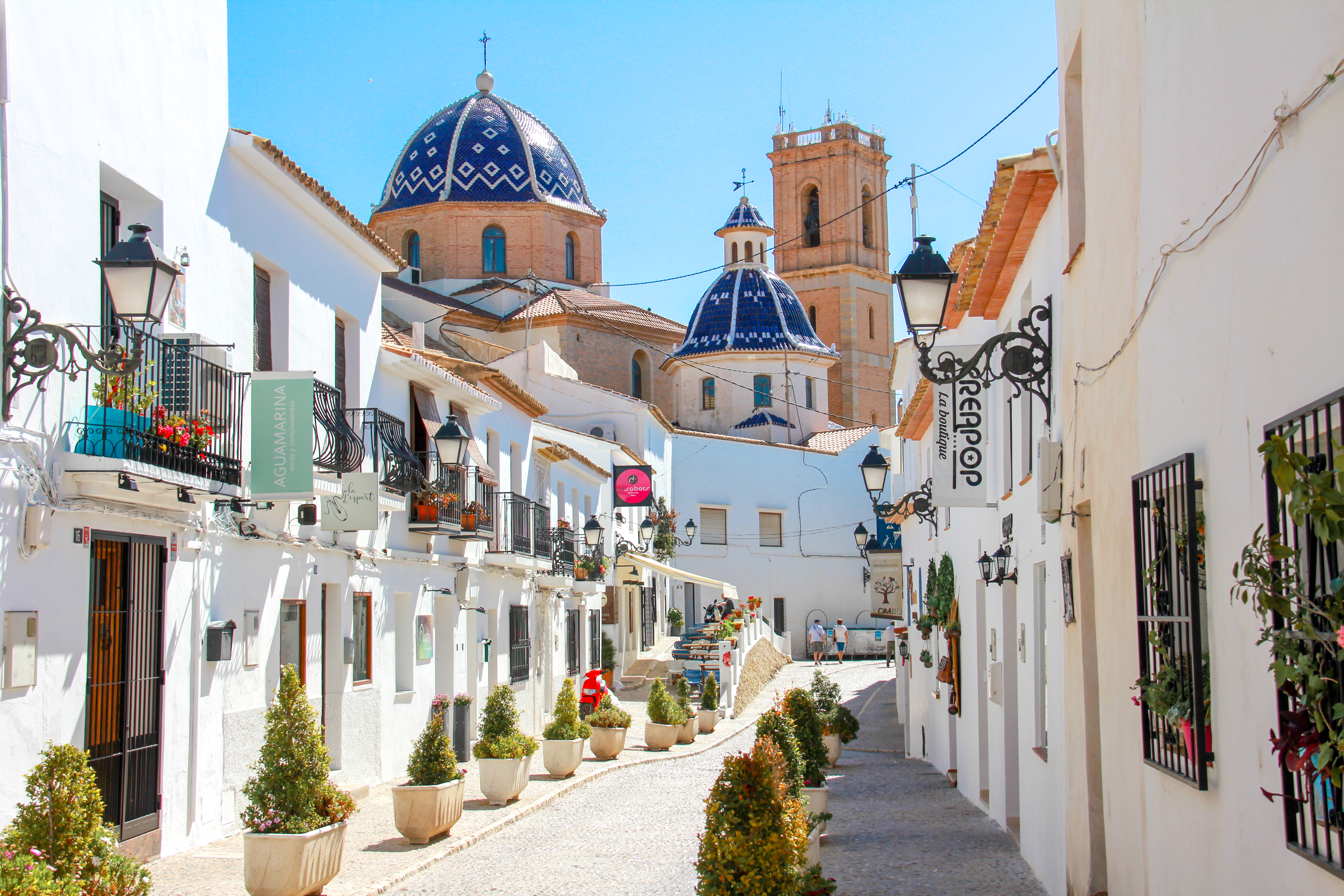 a street with white buildings and blue dome