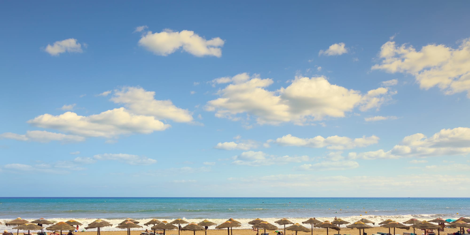 a beach with umbrellas and chairs