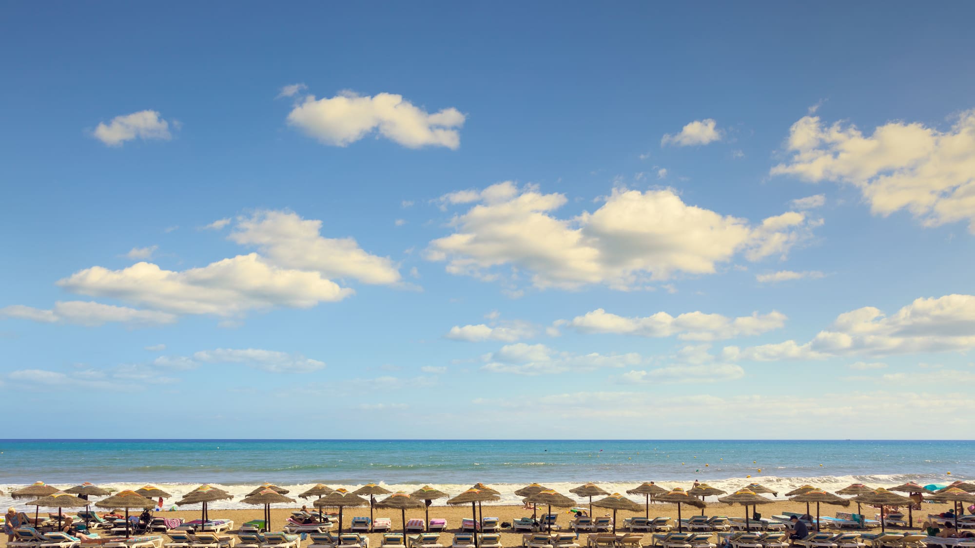 a beach with umbrellas and chairs