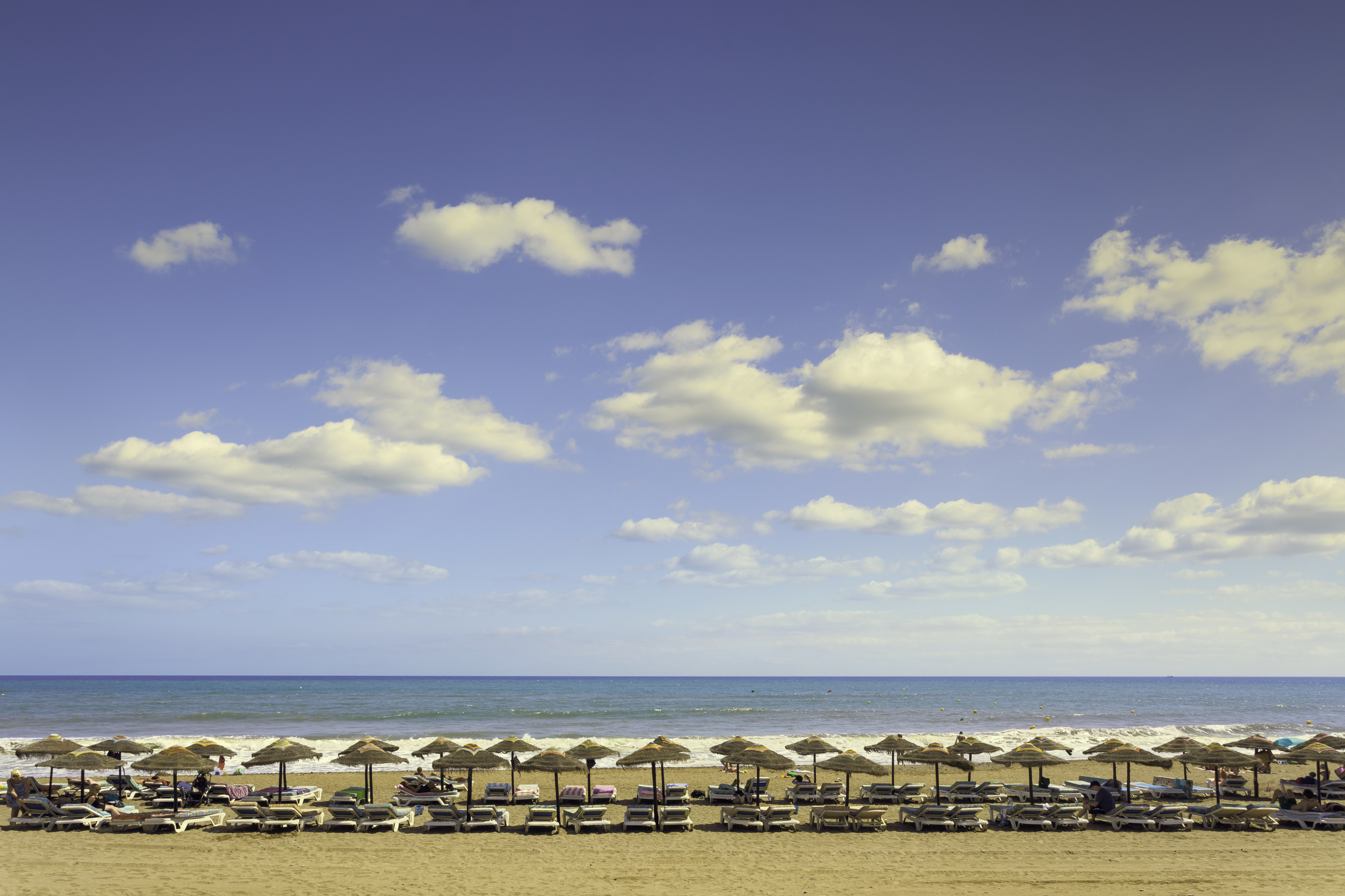 a beach with umbrellas and chairs