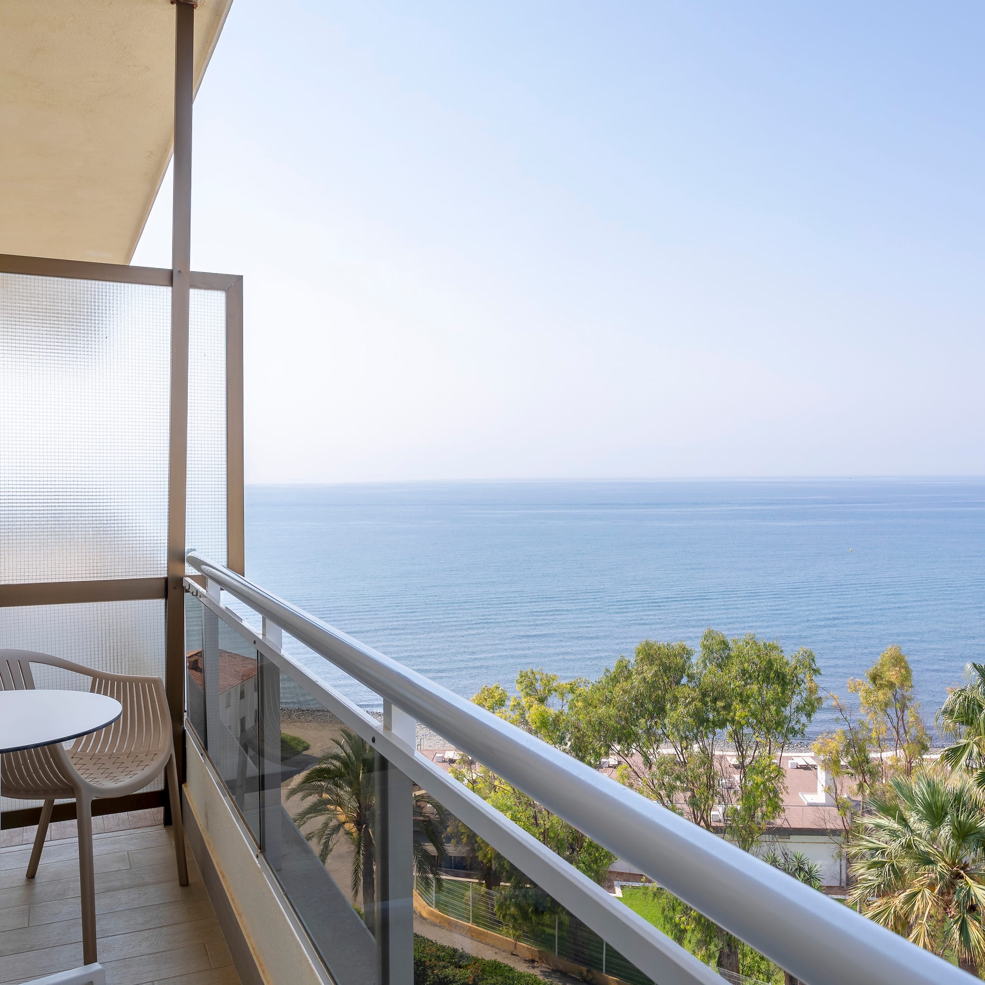 a balcony with a table and chairs overlooking the ocean