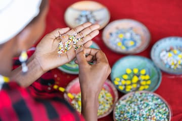 a person holding small colorful beads