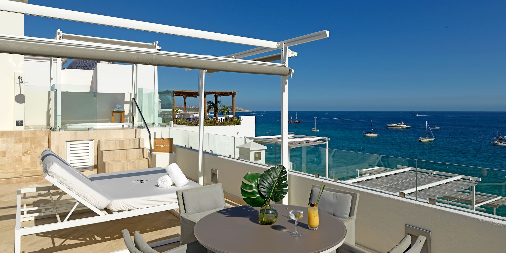 a patio with a table and chairs overlooking the ocean