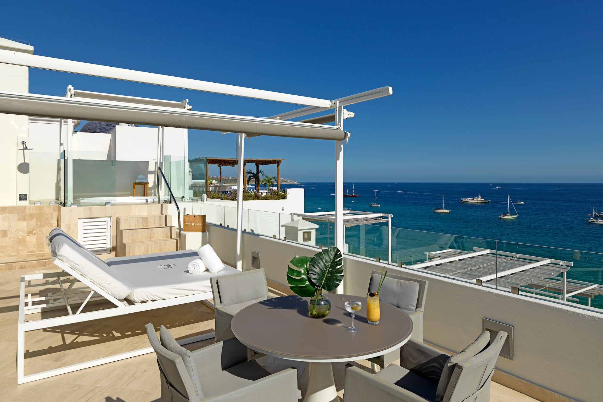 a patio with a table and chairs overlooking the ocean