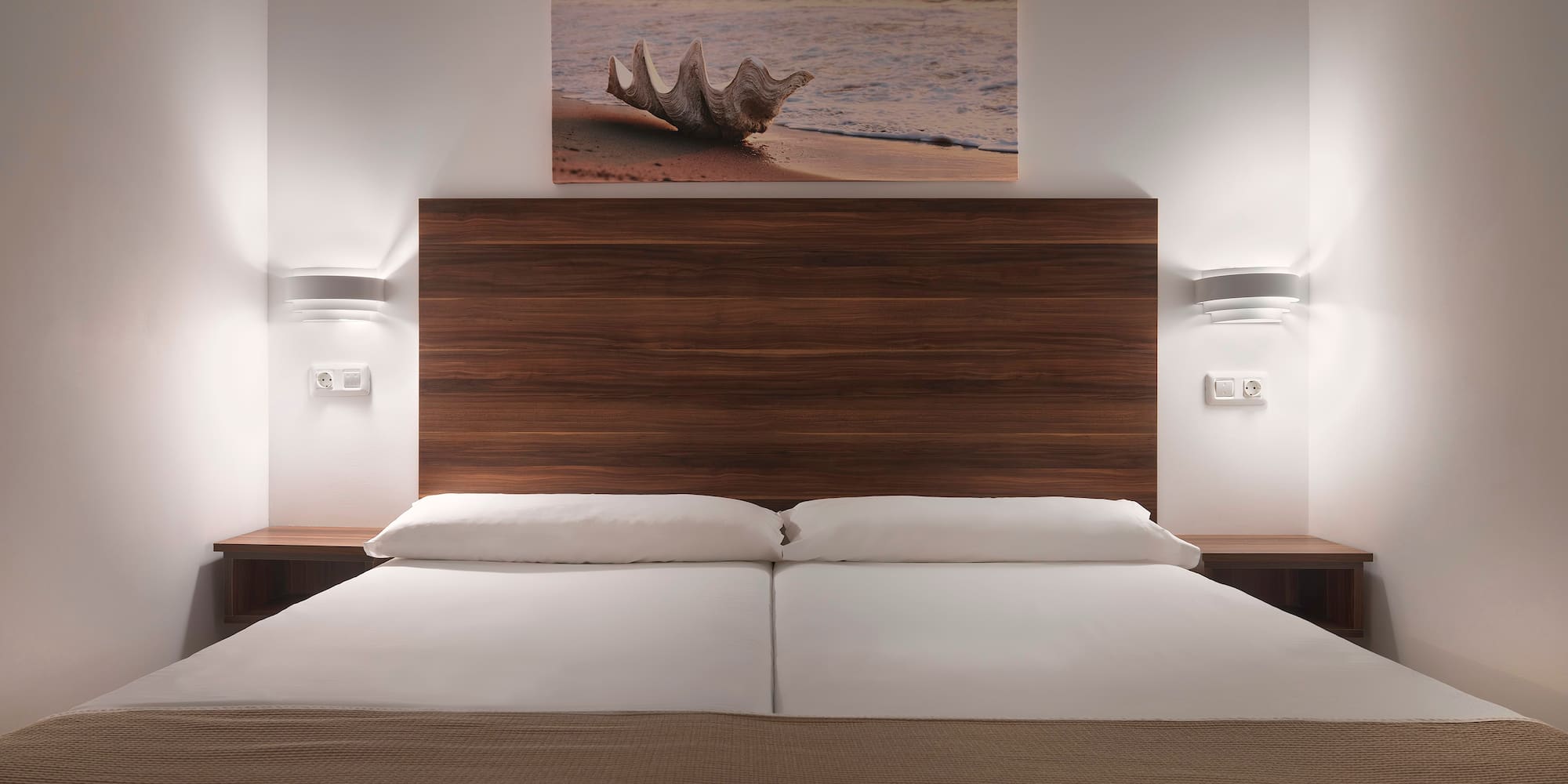 a bed with a wood headboard and a picture above it