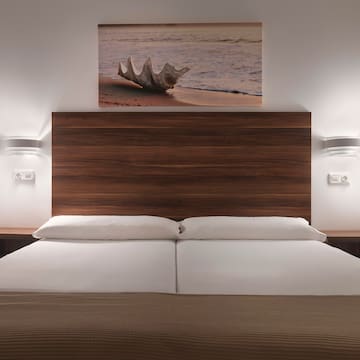 a bed with a wood headboard and a picture above it
