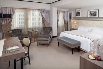 a room with a bed and chairs