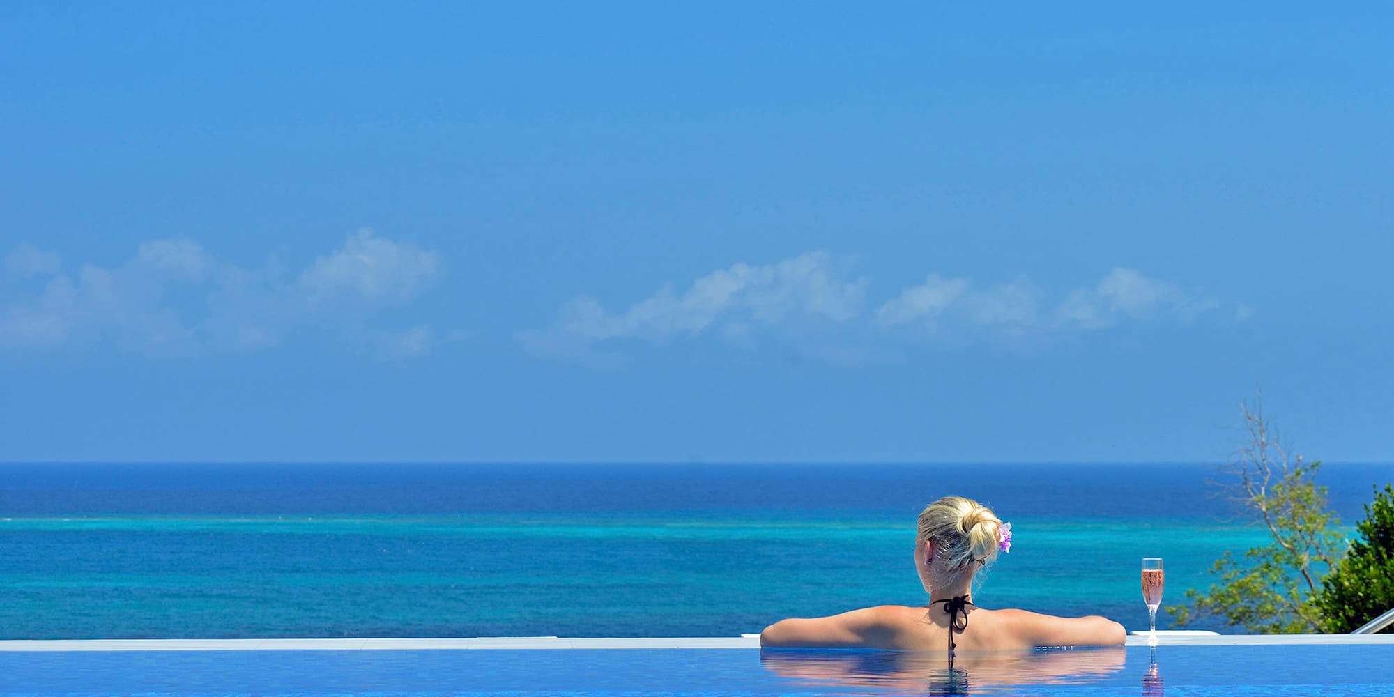 a woman in a pool with a body of water in the background