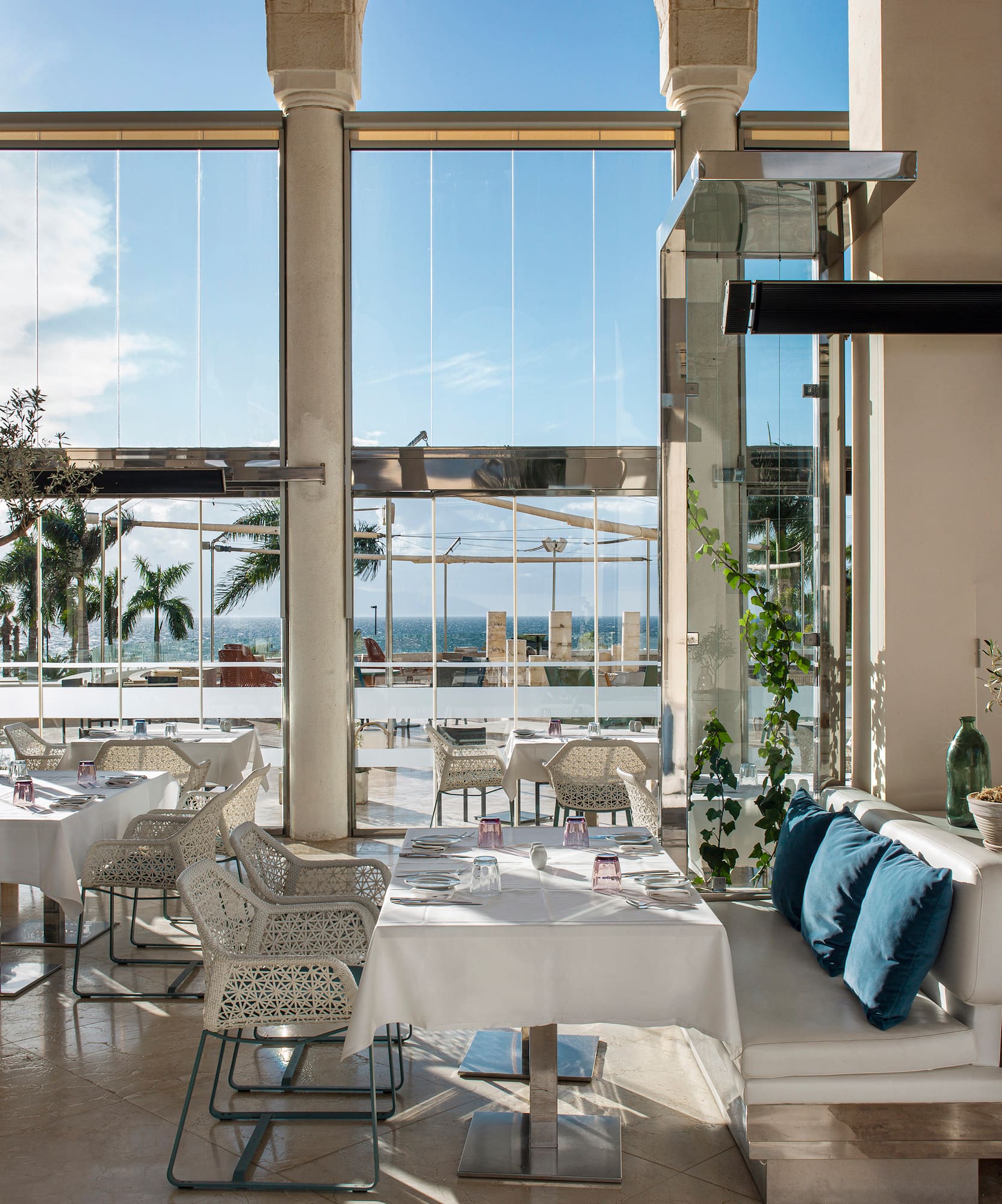 a room with white tables and chairs and a large window