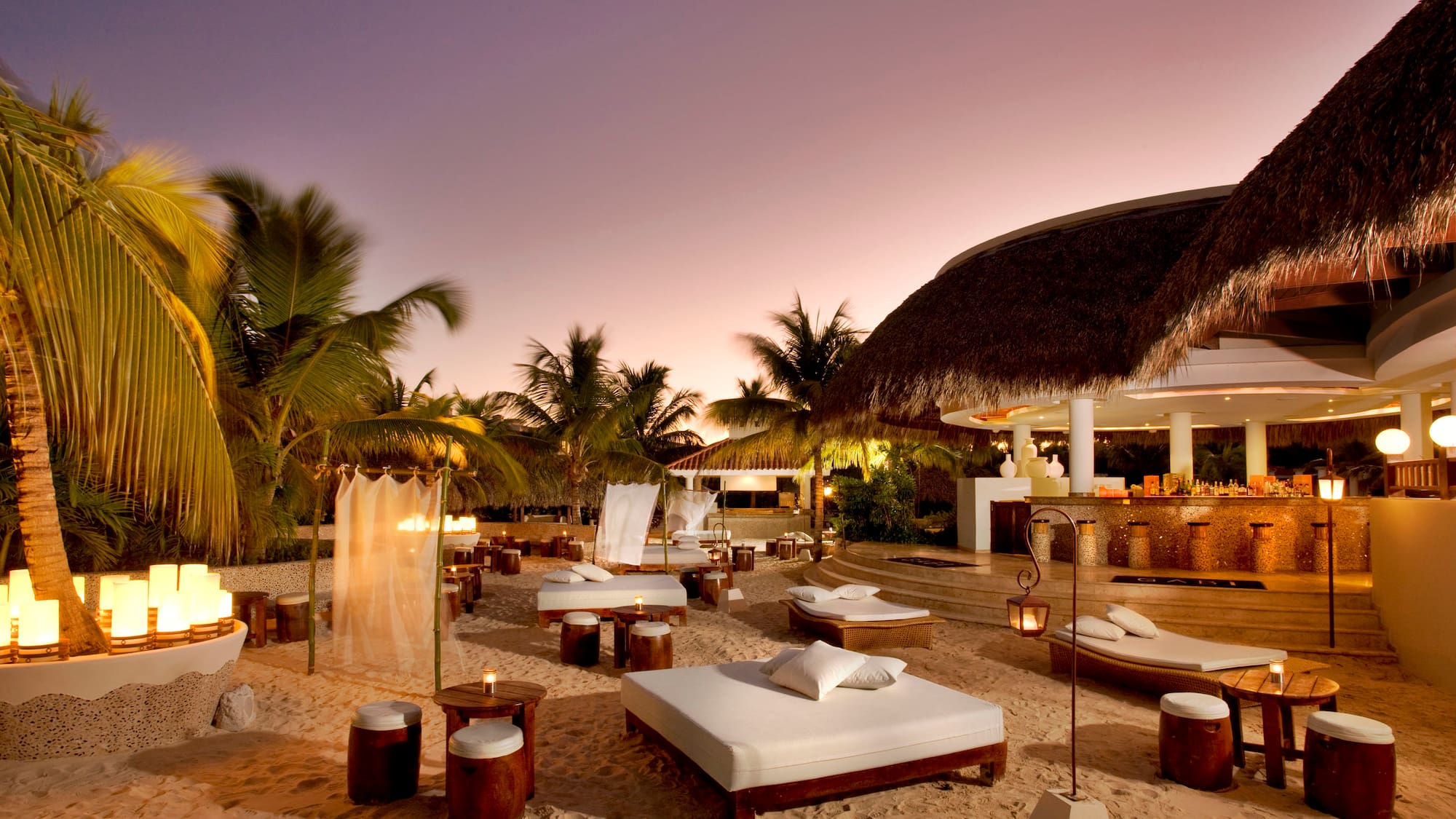 a beach bar with lounge chairs and palm trees