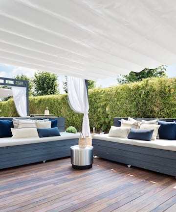 a patio with a white canopy and couches