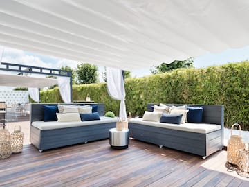 a patio with a white canopy and couches