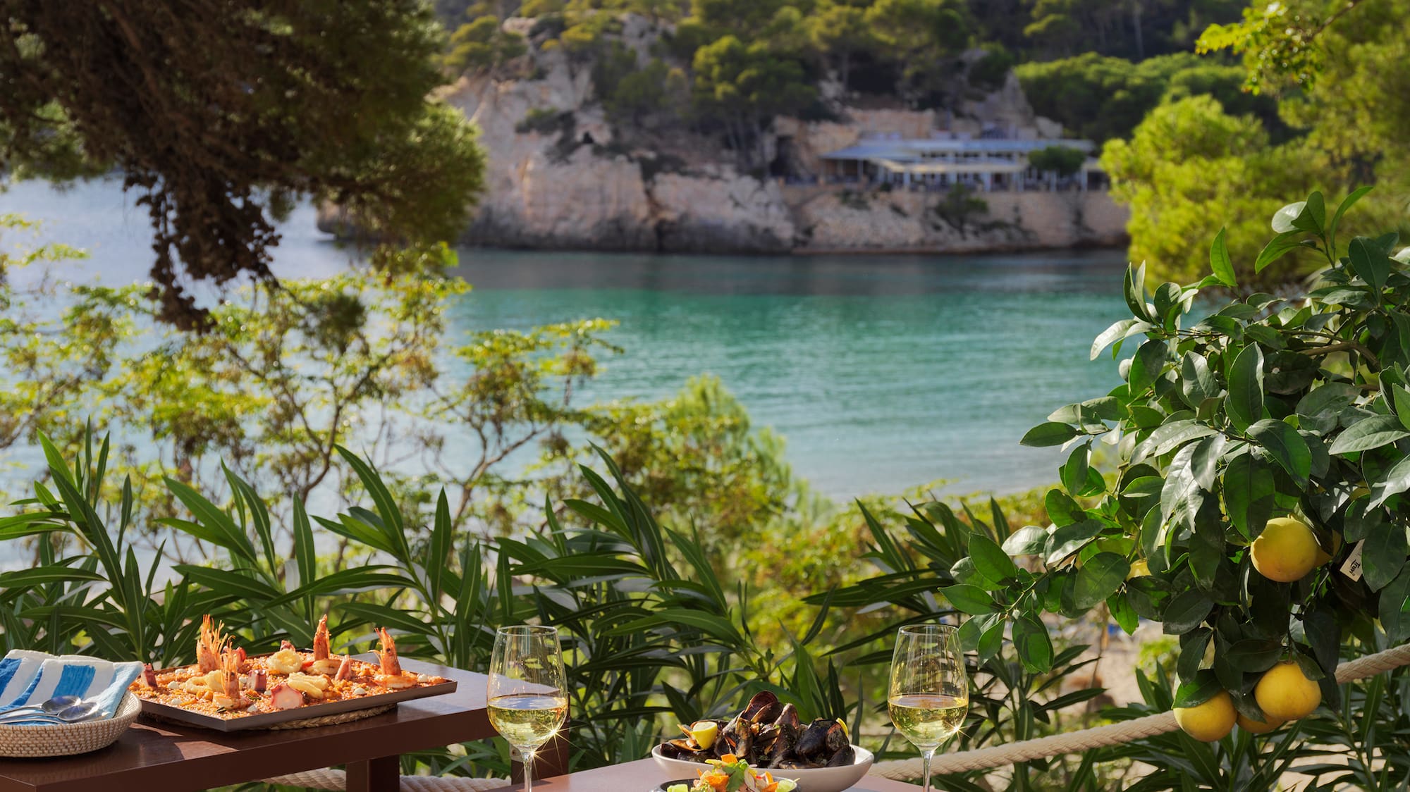 a table with food on it and a body of water in the background