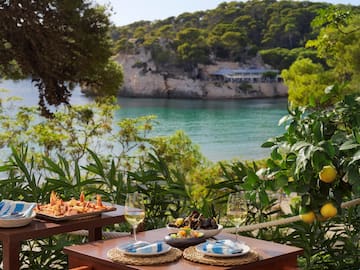a table with food on it and a body of water in the background