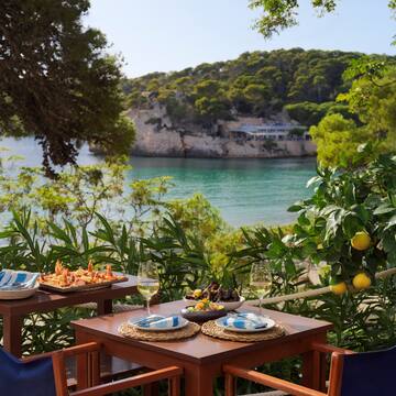 a table with food on it and a body of water in the background