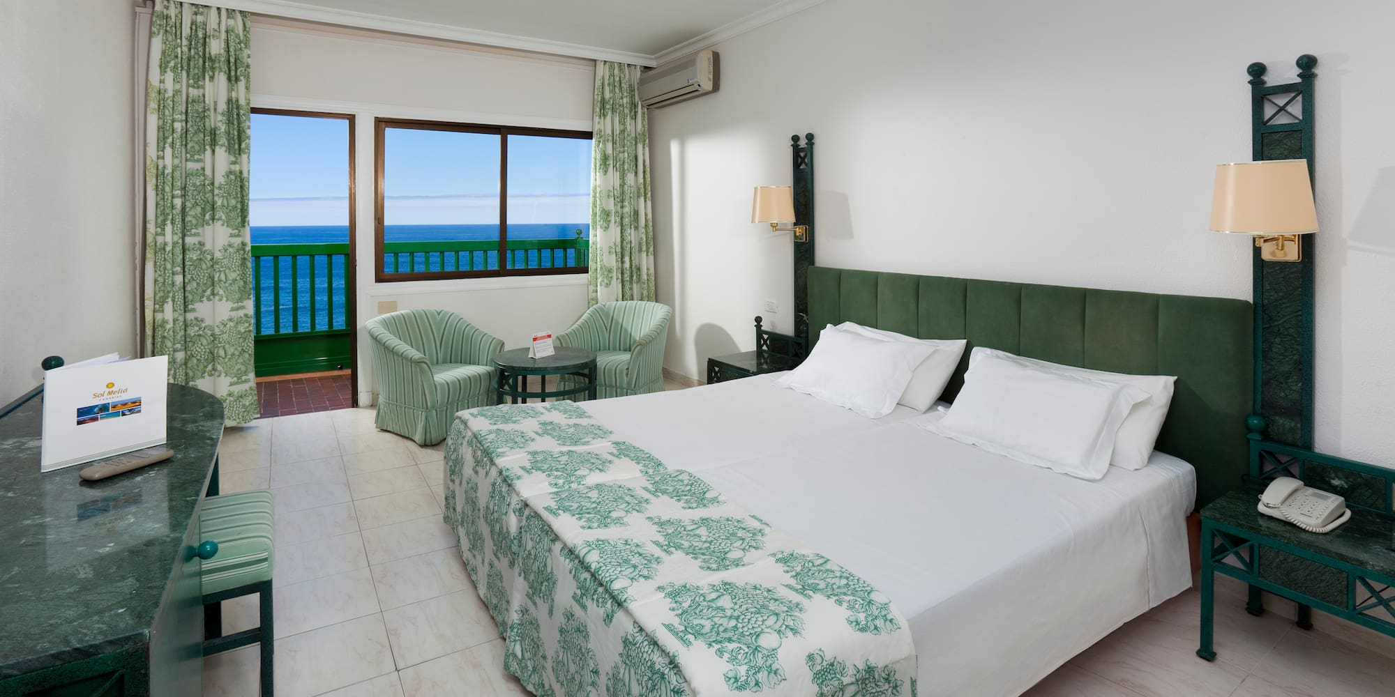 a bedroom with a bed and chairs