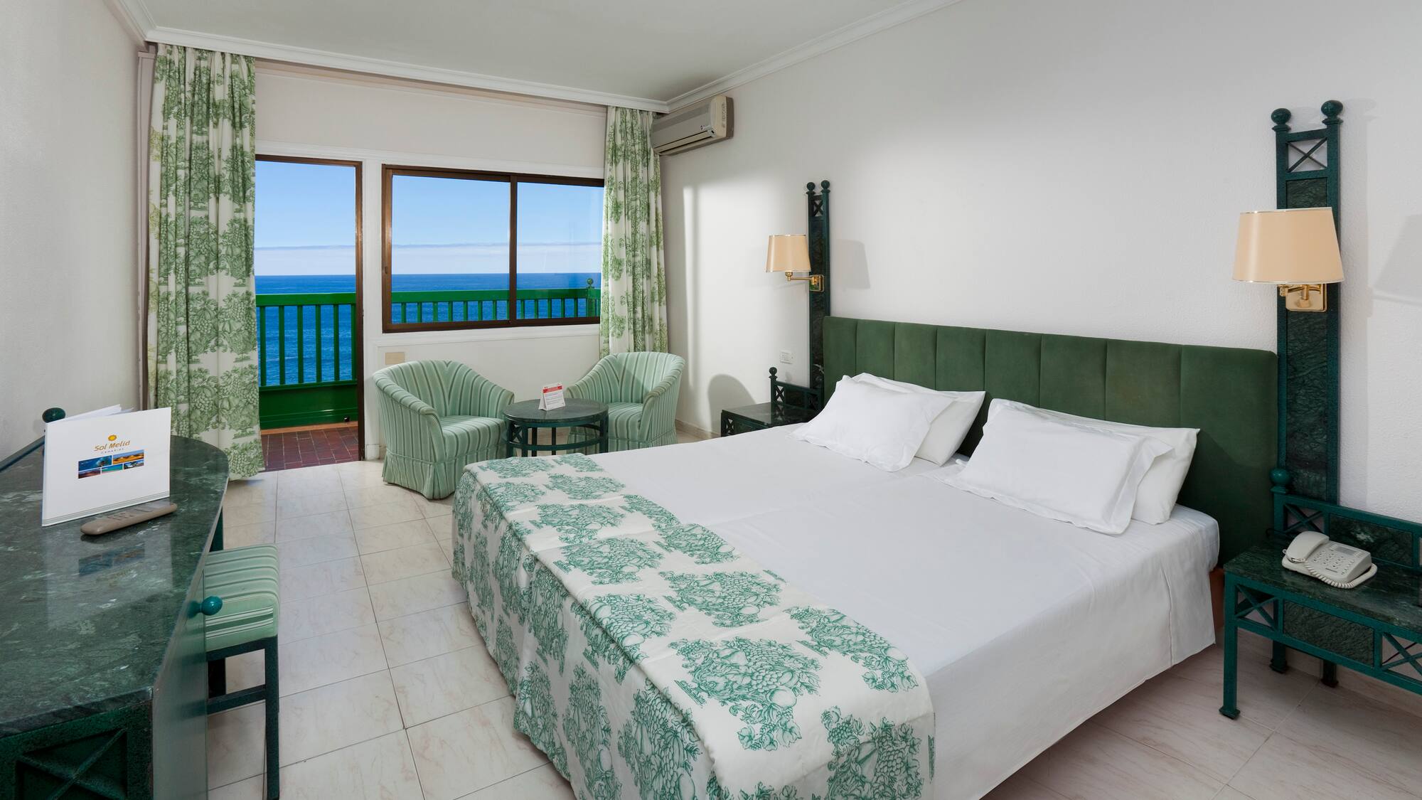 a bedroom with a bed and chairs