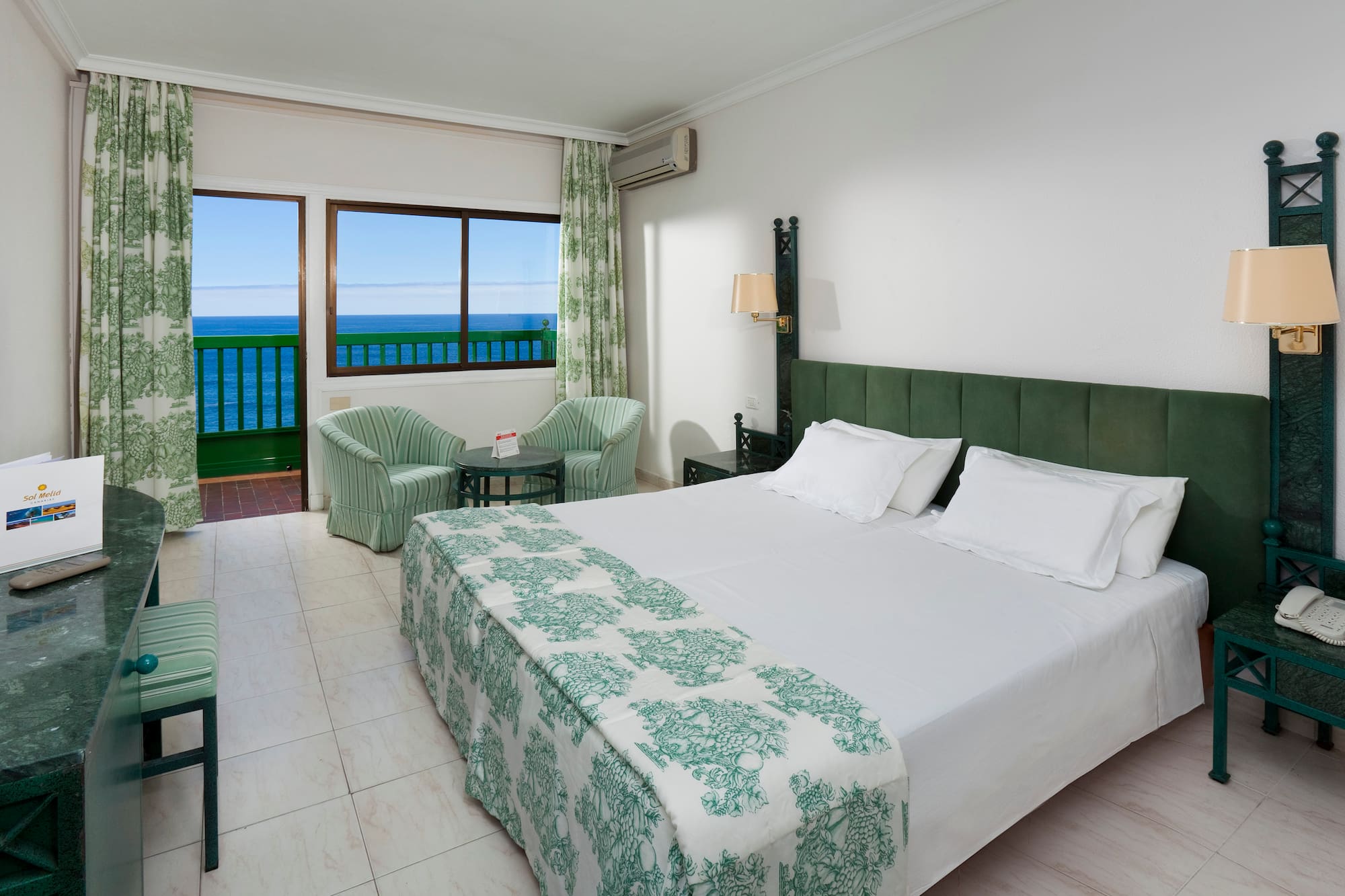 a bedroom with a bed and chairs