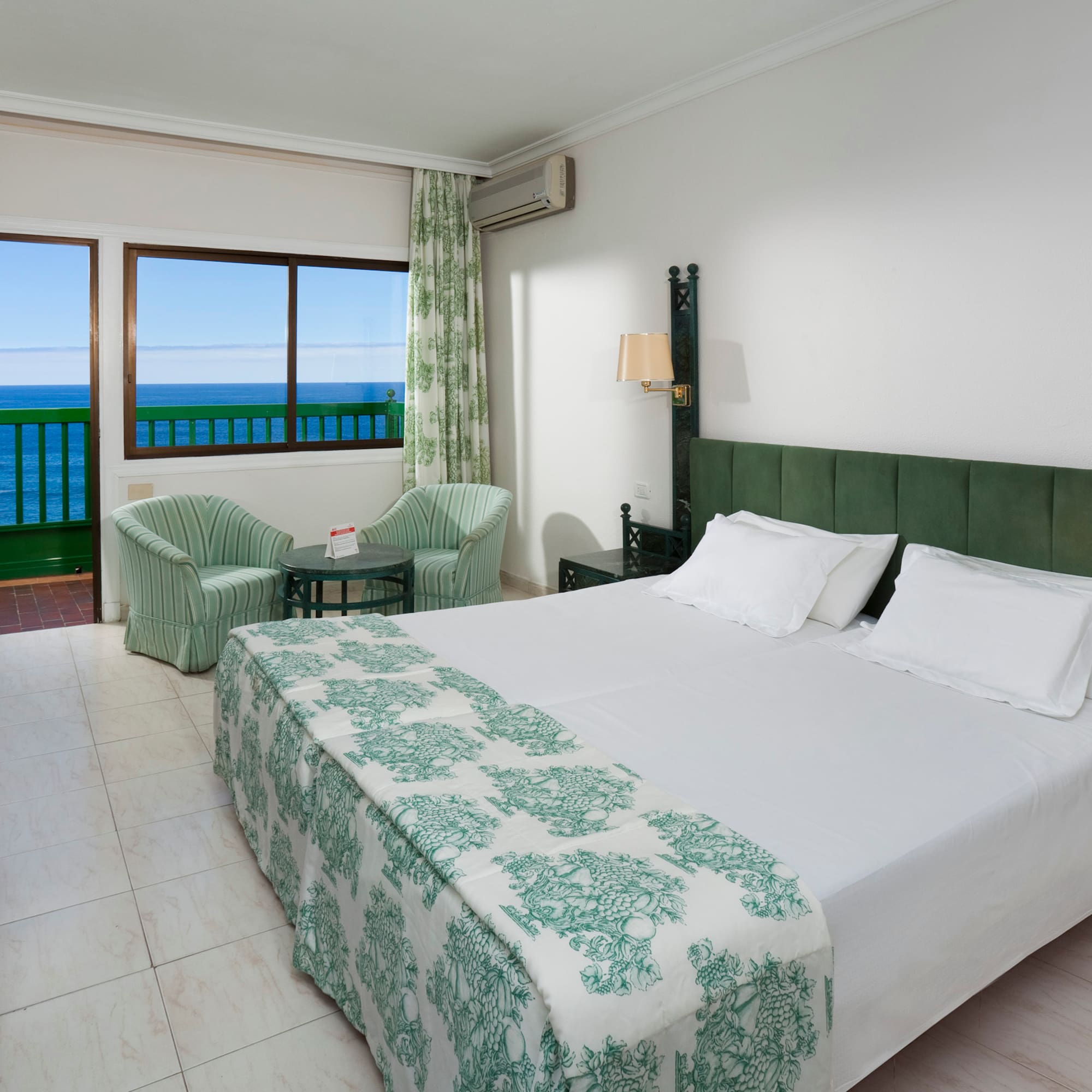 a bedroom with a bed and chairs