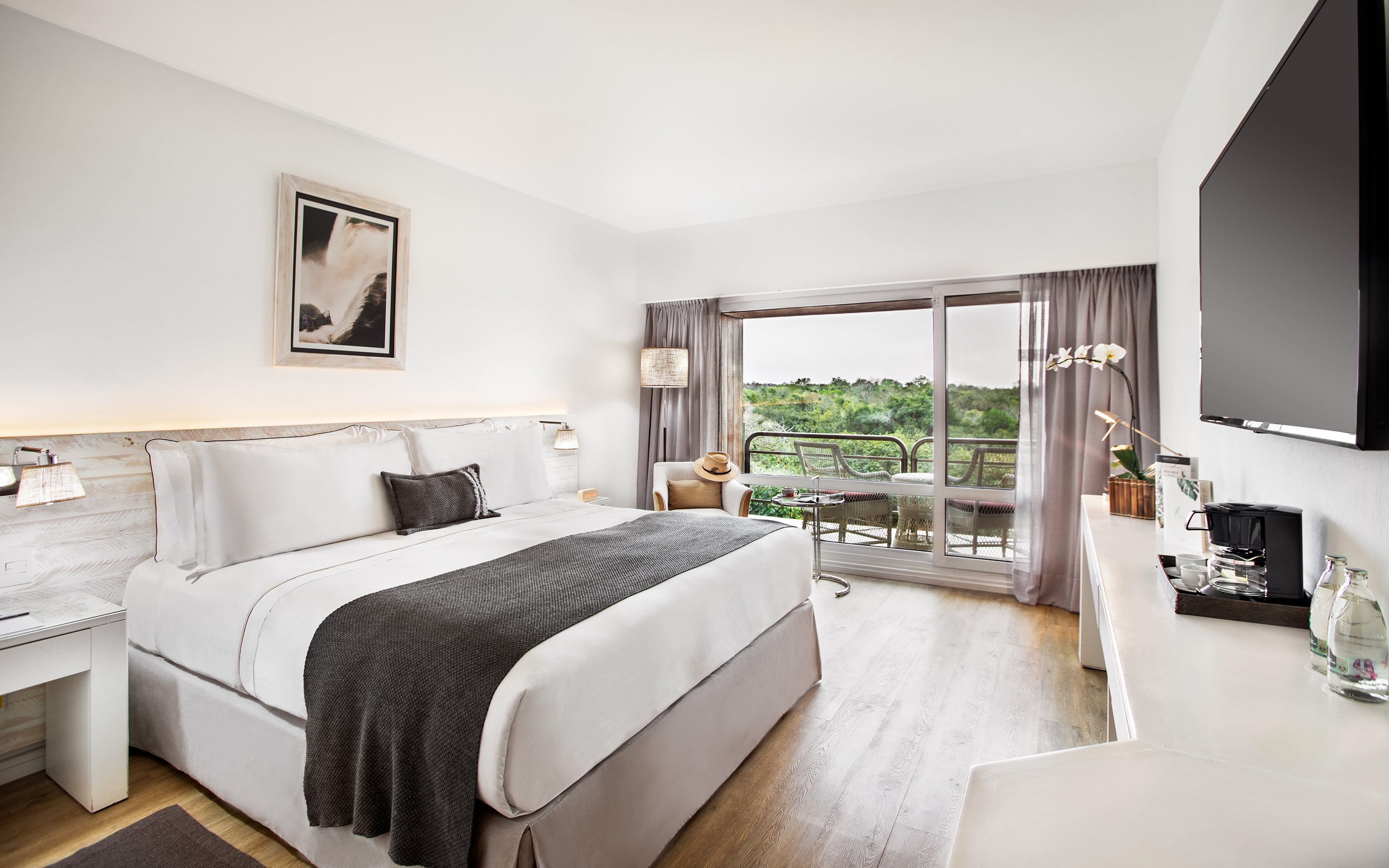 a bedroom with a large bed and a glass door