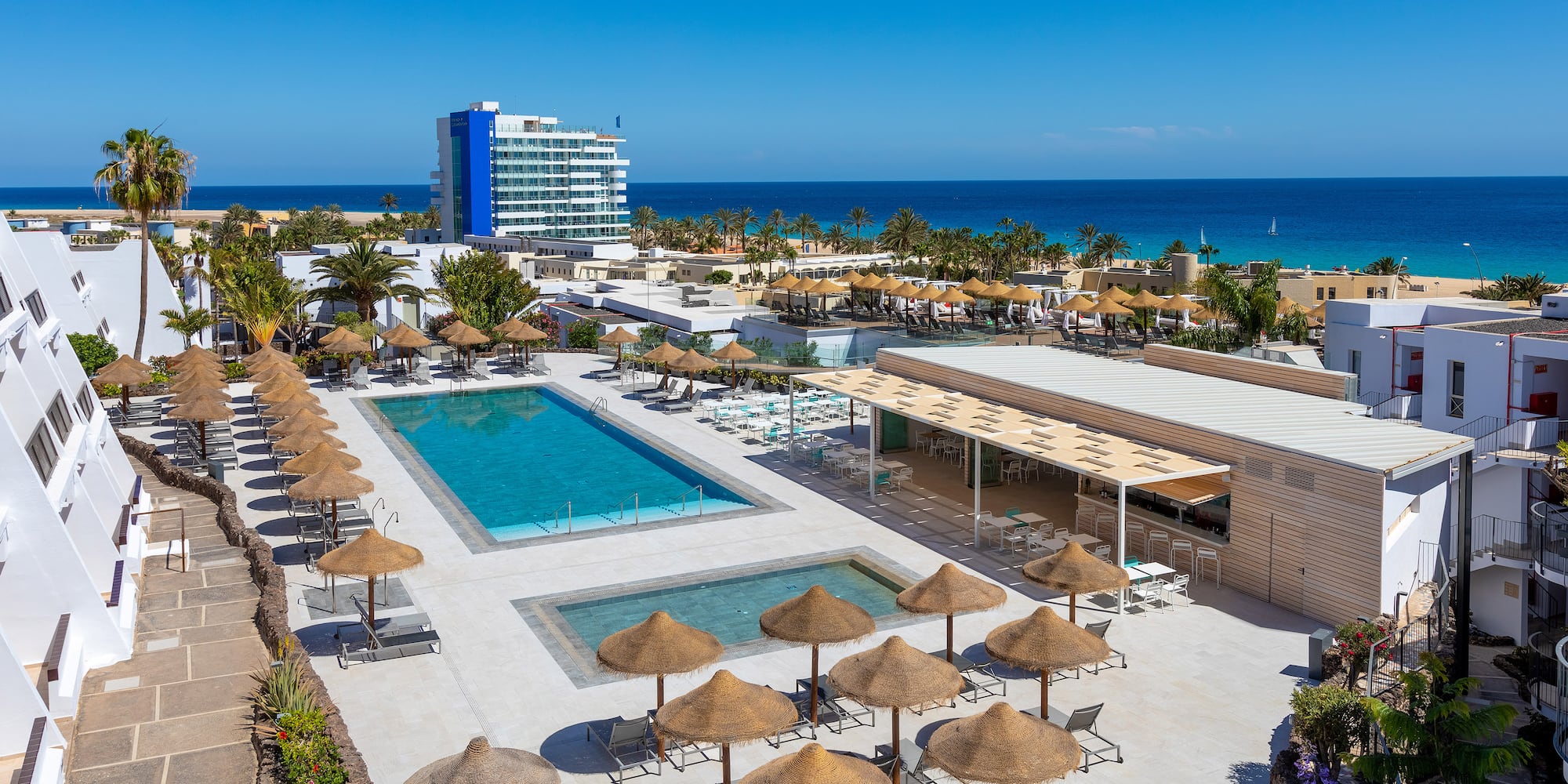 a pool and umbrellas by a building