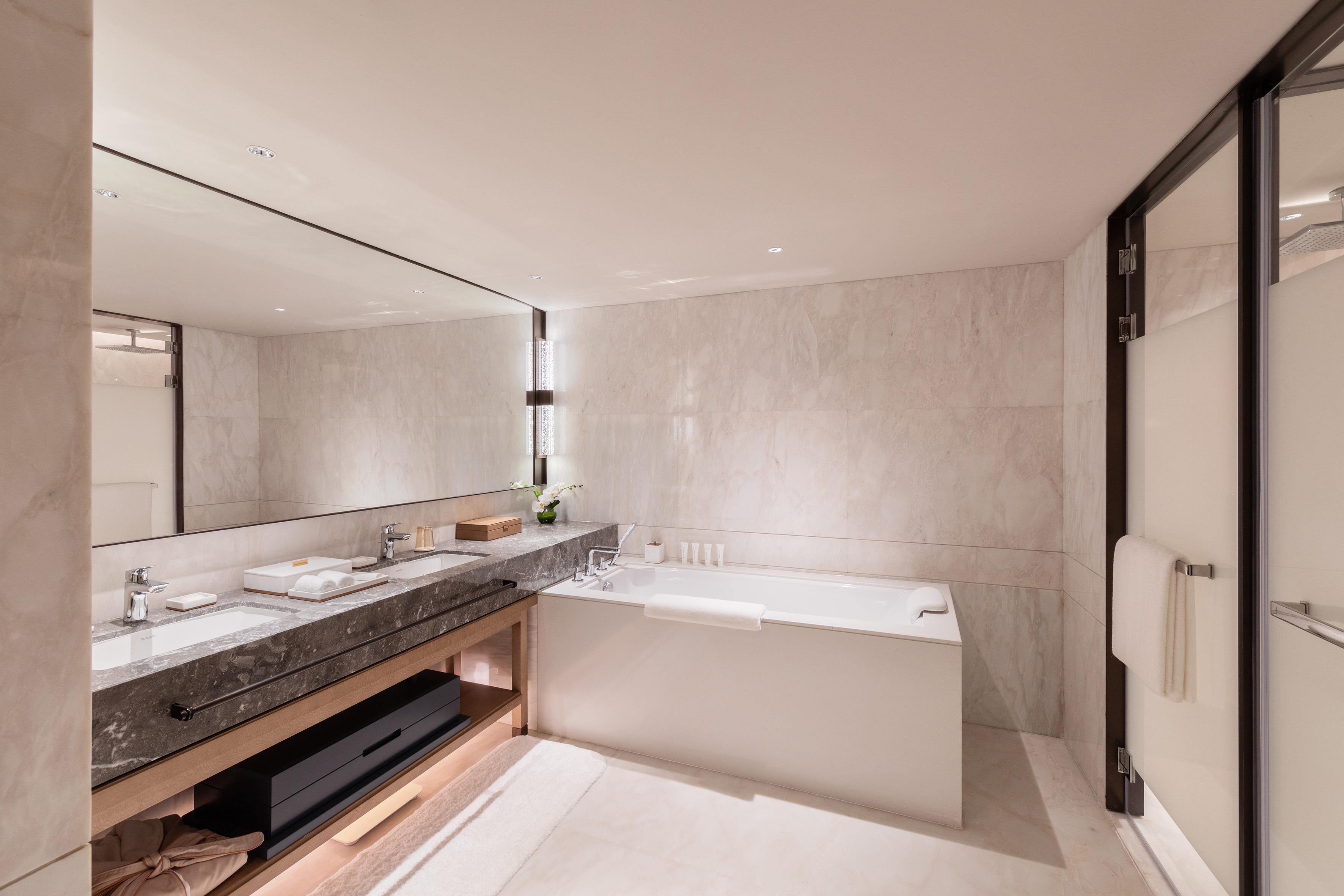 Luxury marble bathroom with double vanity, soaking tub, and glass shower.