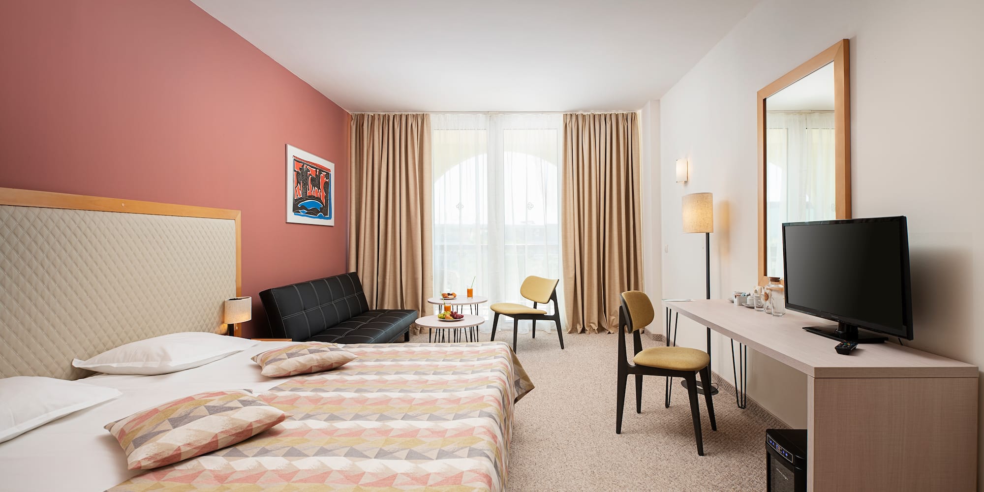 a room with a bed and a desk and chairs