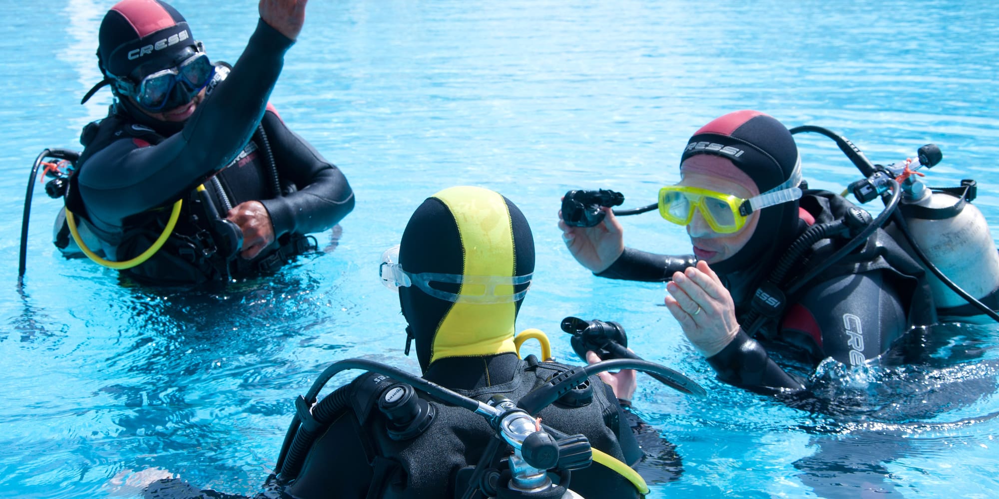 a group of people in scuba gear in a pool