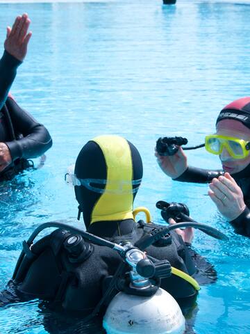 a group of people in scuba gear in a pool