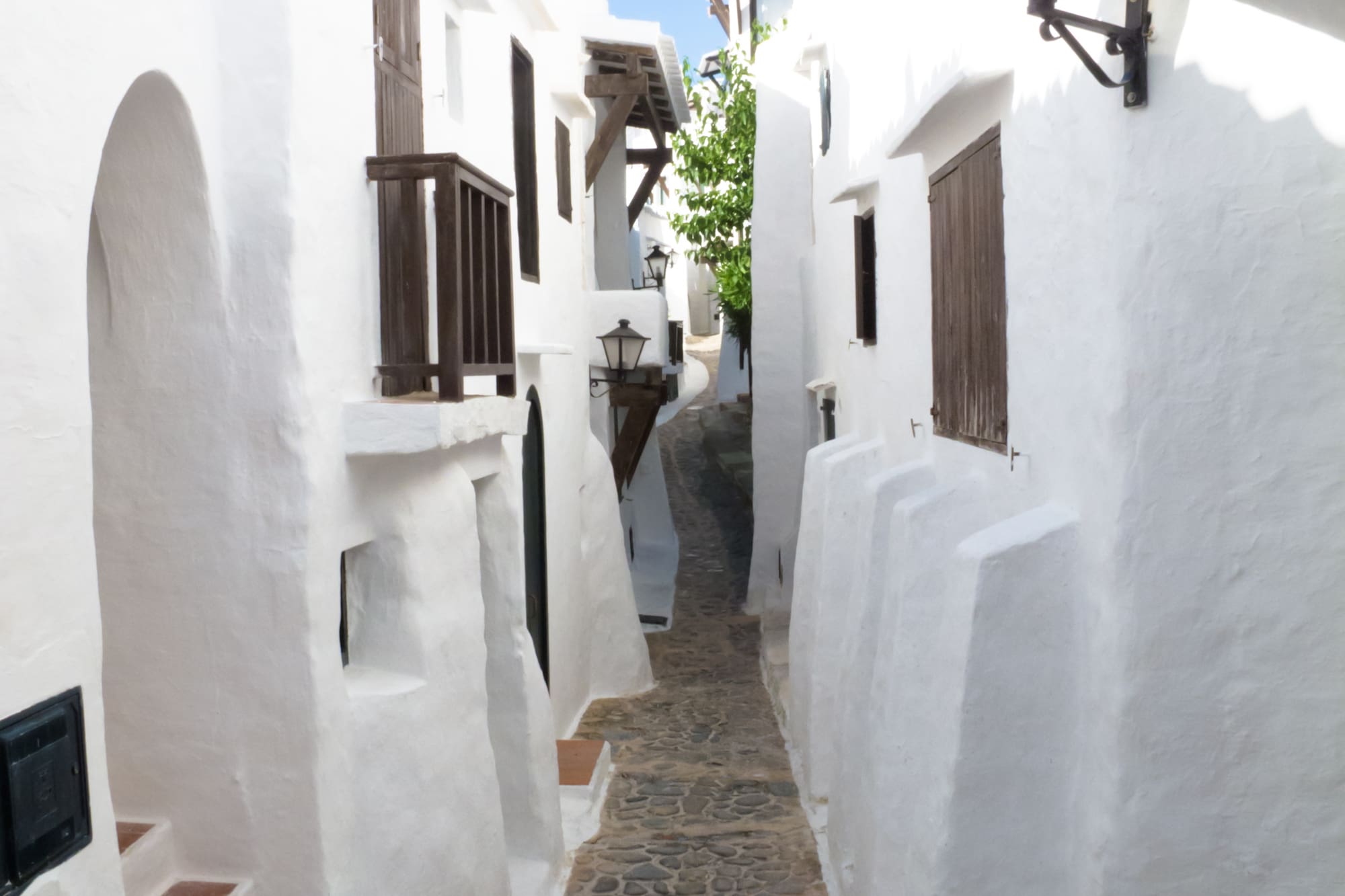 a narrow street with white buildings