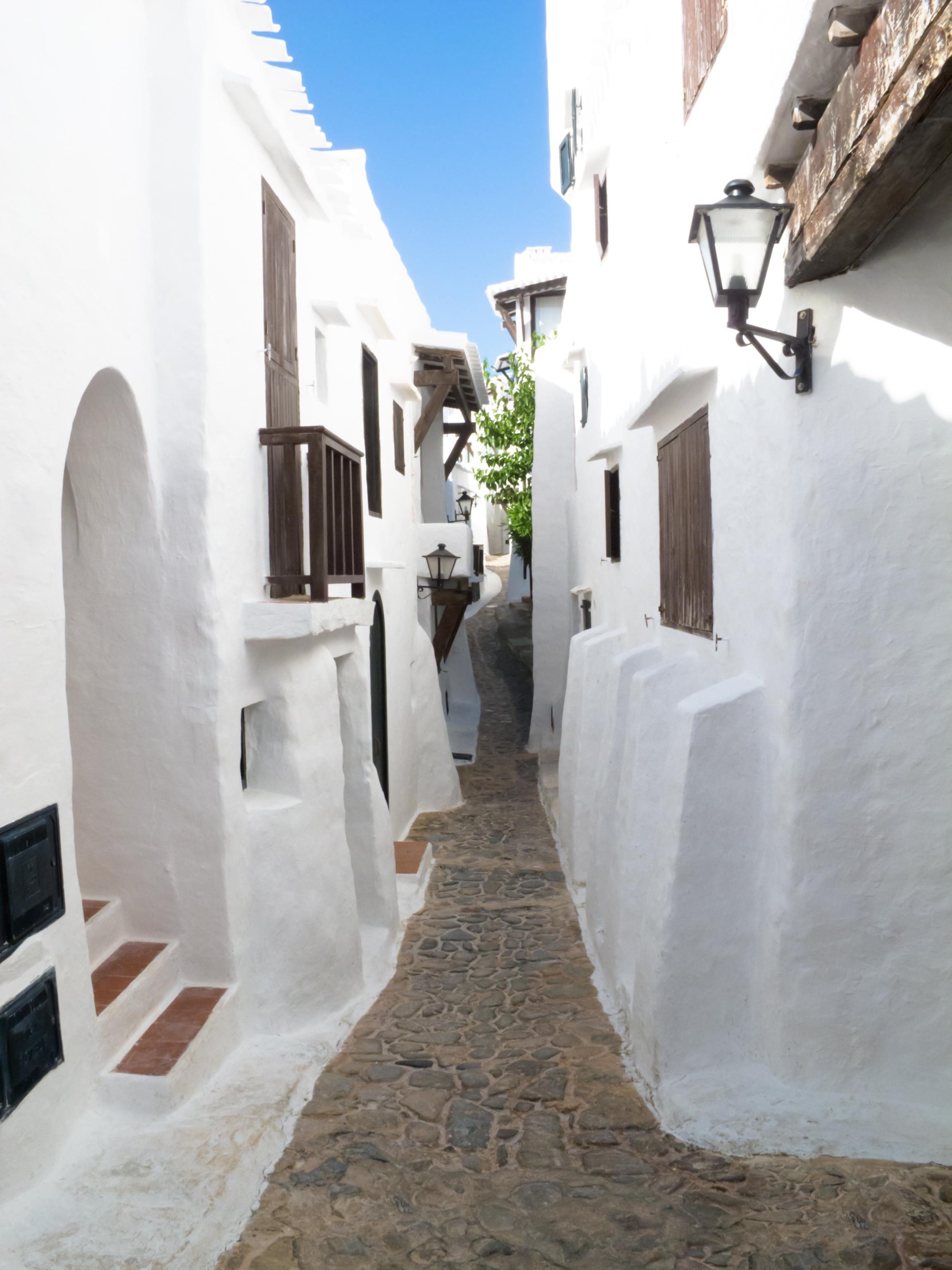 a narrow street with white buildings