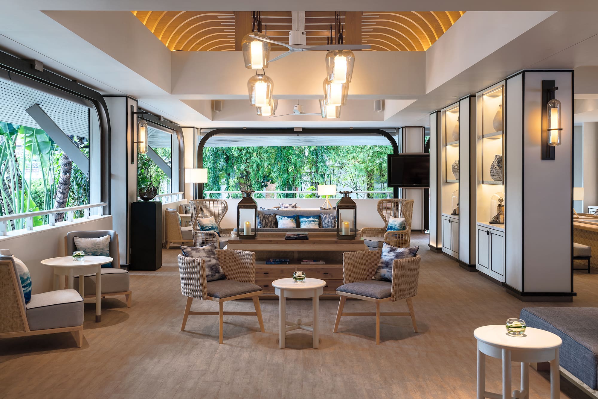 Tropical resort lounge with modern decor, comfortable seating, and lush garden view.