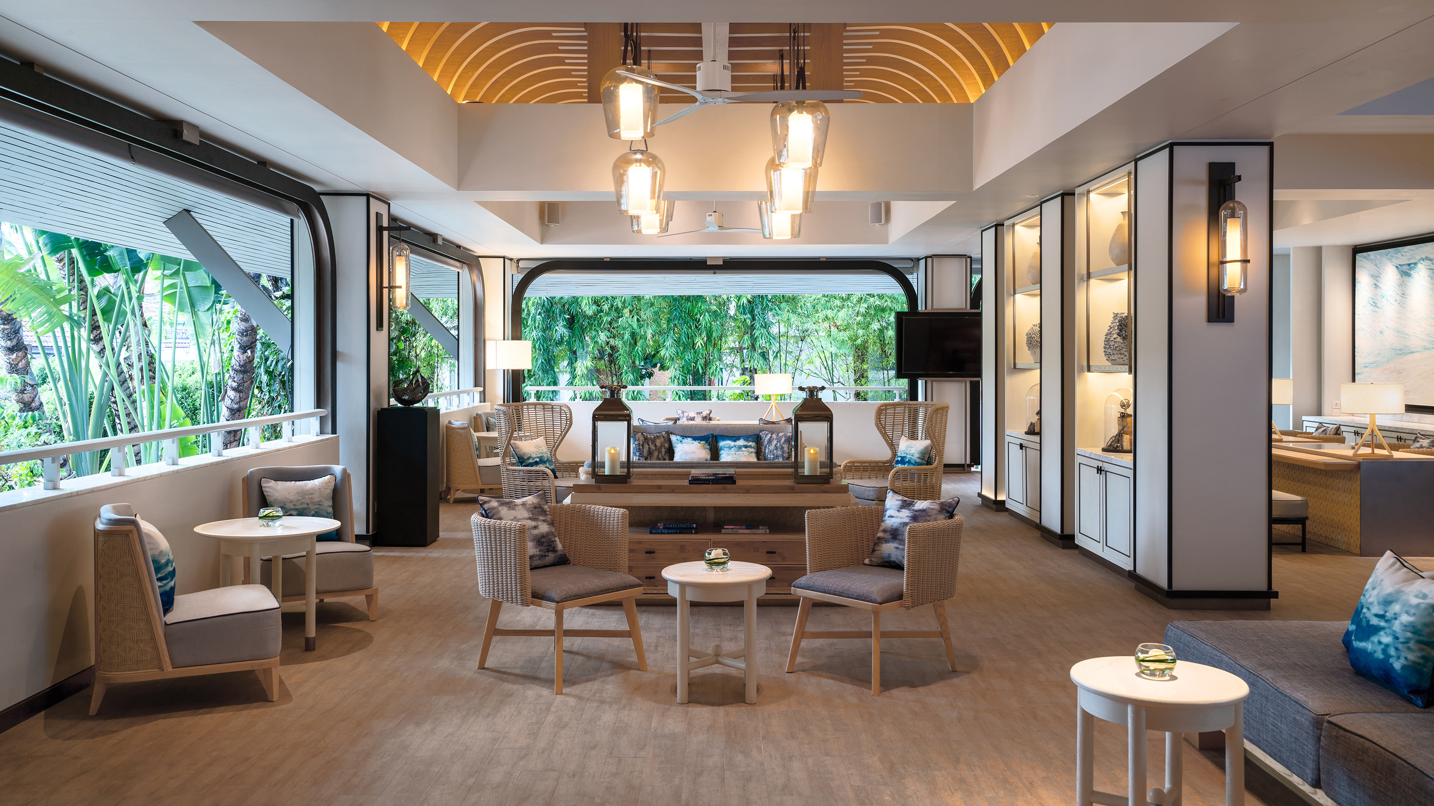 Tropical resort lounge with modern decor, comfortable seating, and lush garden view.