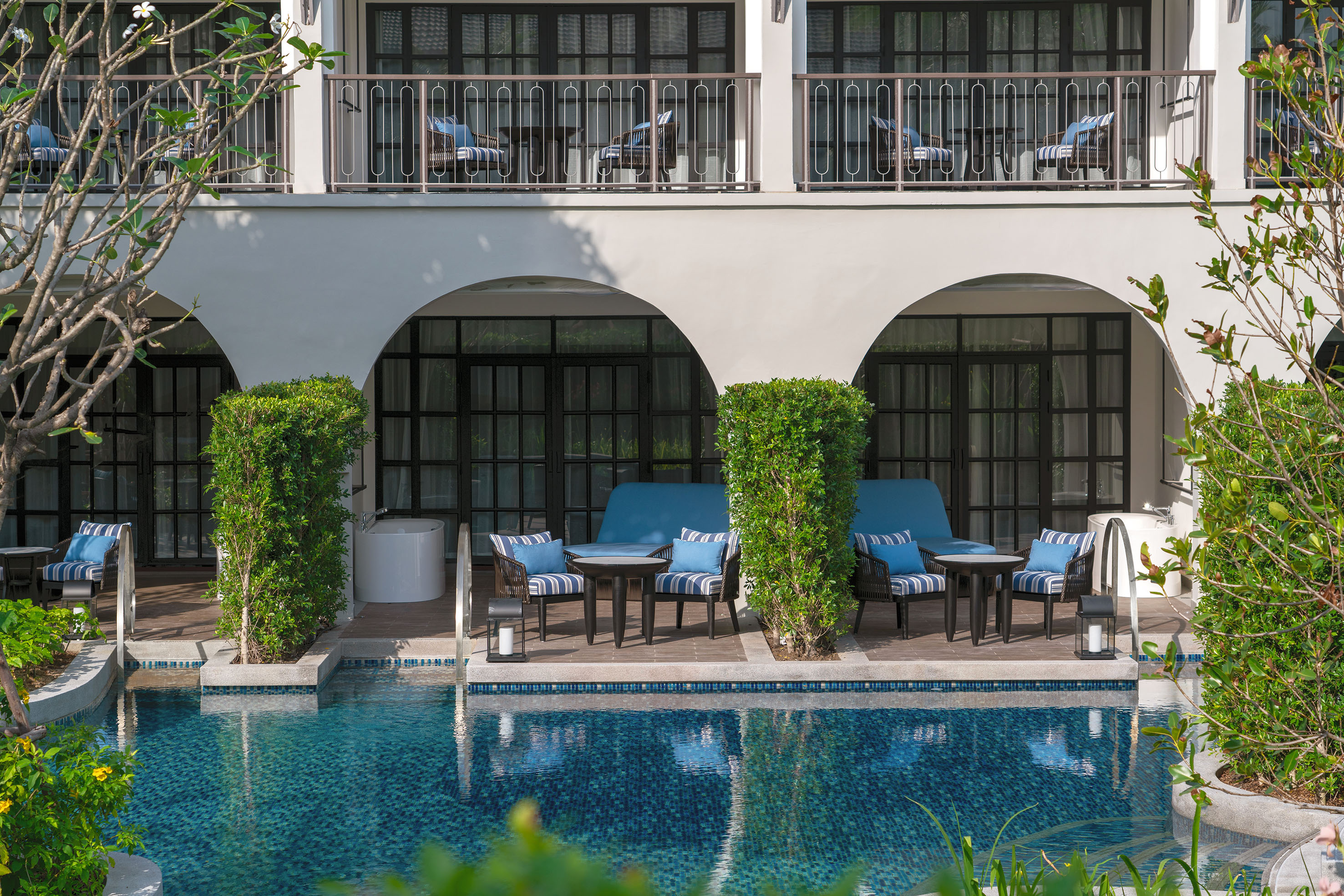 Luxury resort swim-up rooms with pool, balconies, and outdoor lounge area.