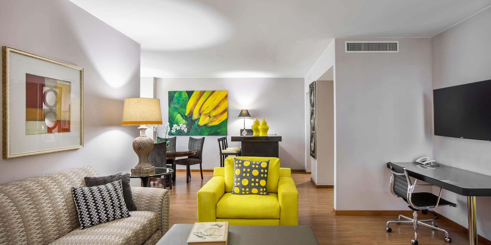 a living room with a piano and yellow couch