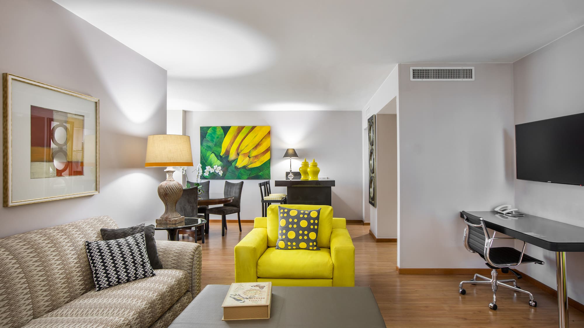 a living room with a piano and yellow couch