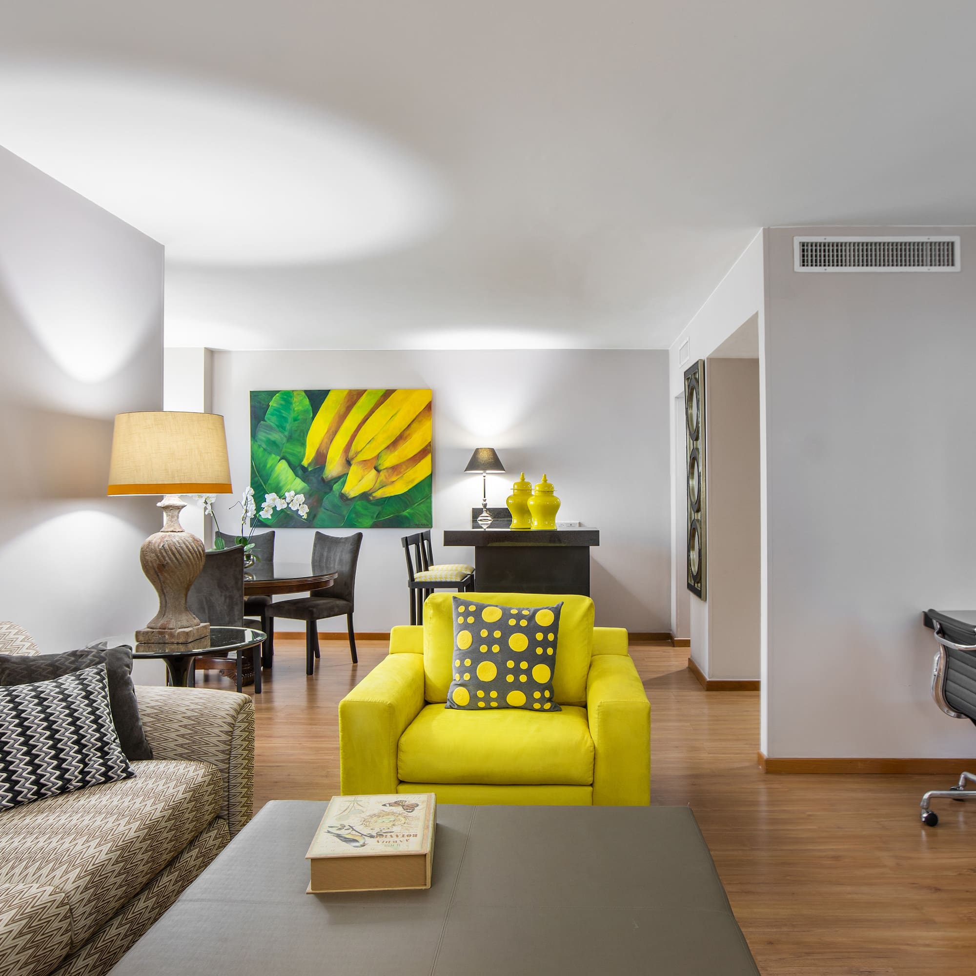 a living room with a piano and yellow couch
