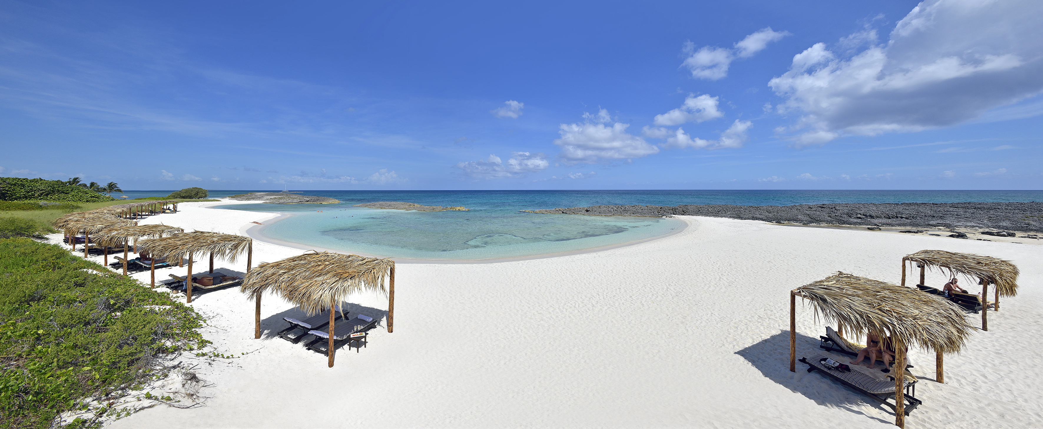a beach with a hut and a straw roof