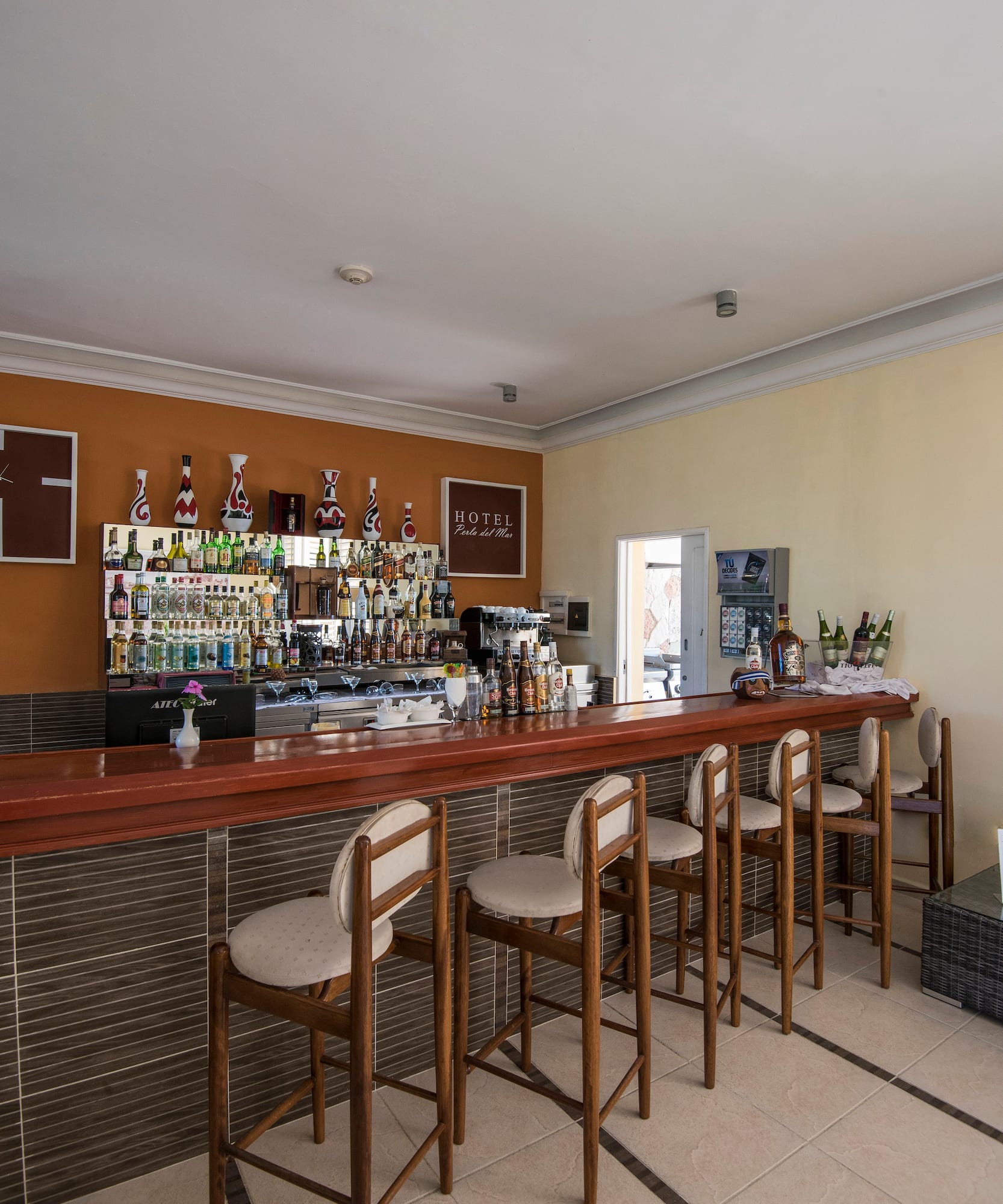 a bar with chairs and bottles on the wall