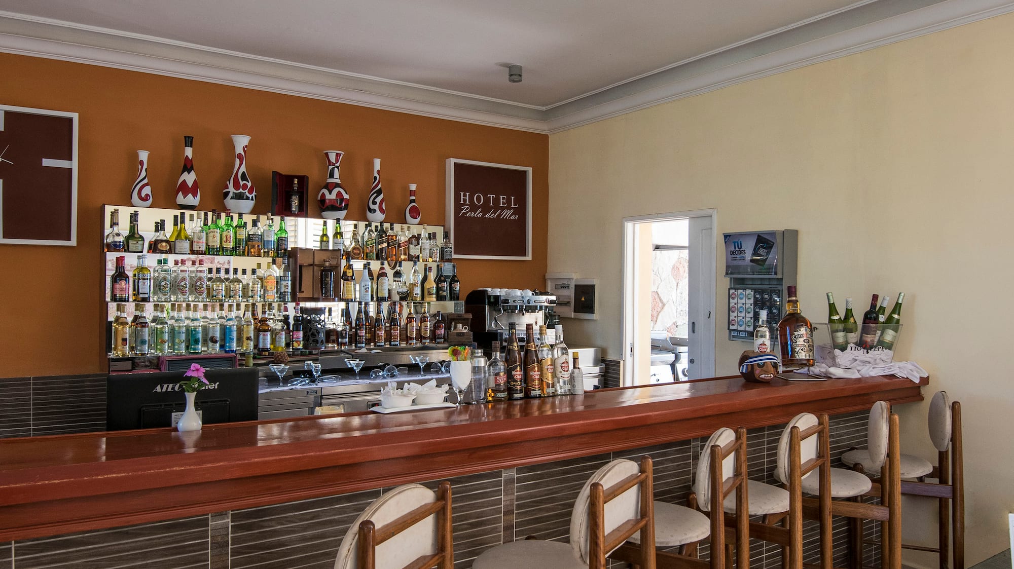 a bar with chairs and bottles on the wall