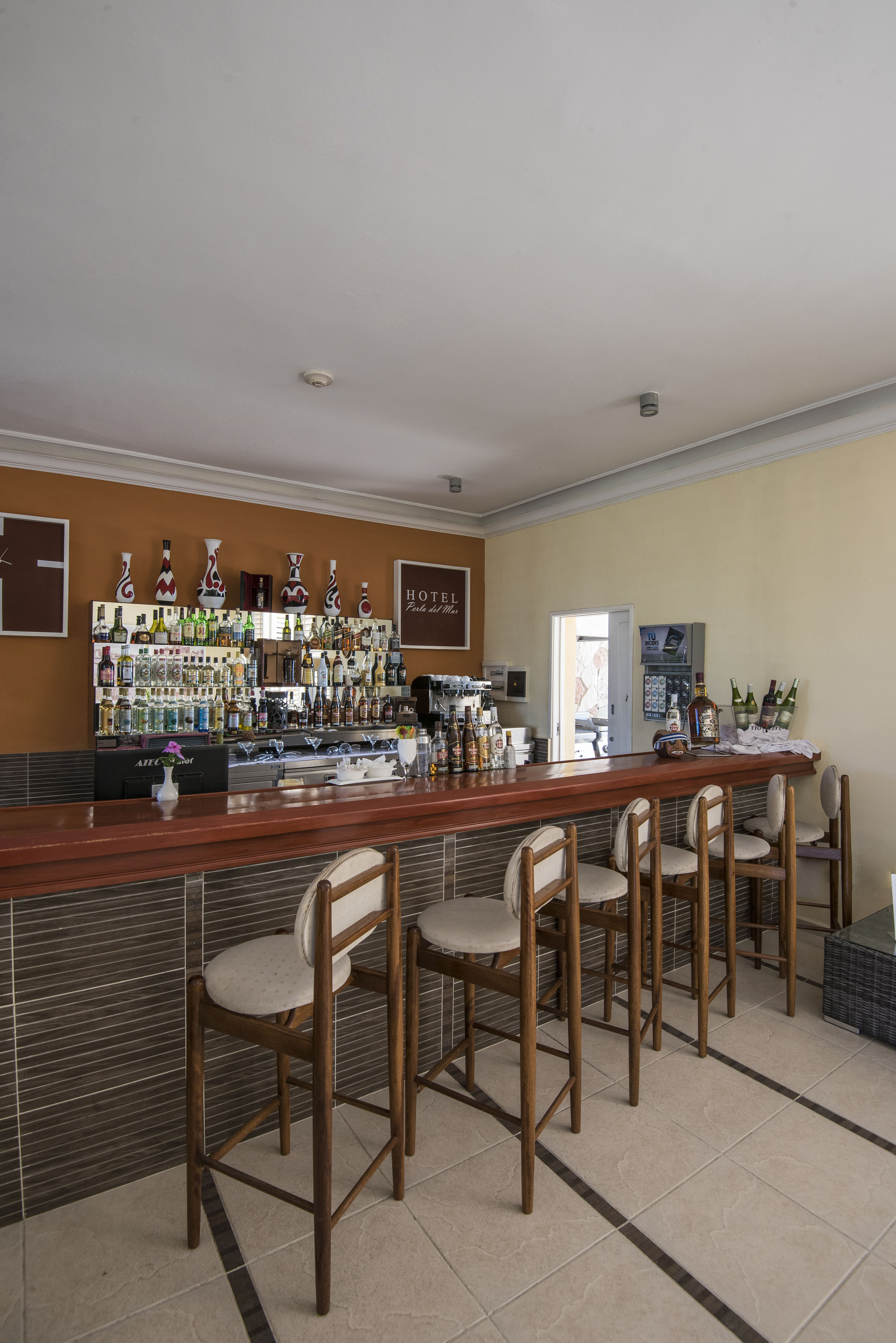 a bar with chairs and bottles on the wall