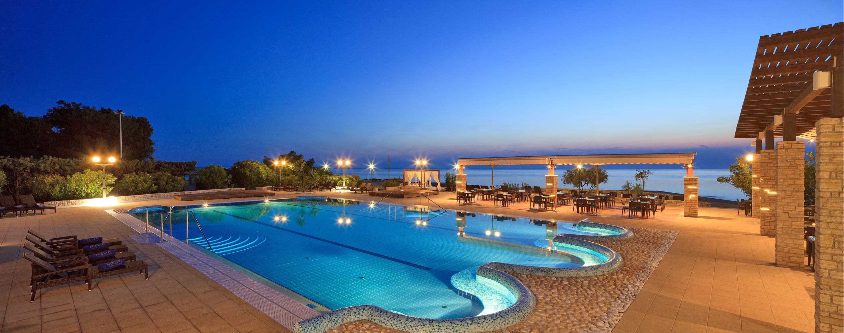 a swimming pool with a deck and chairs