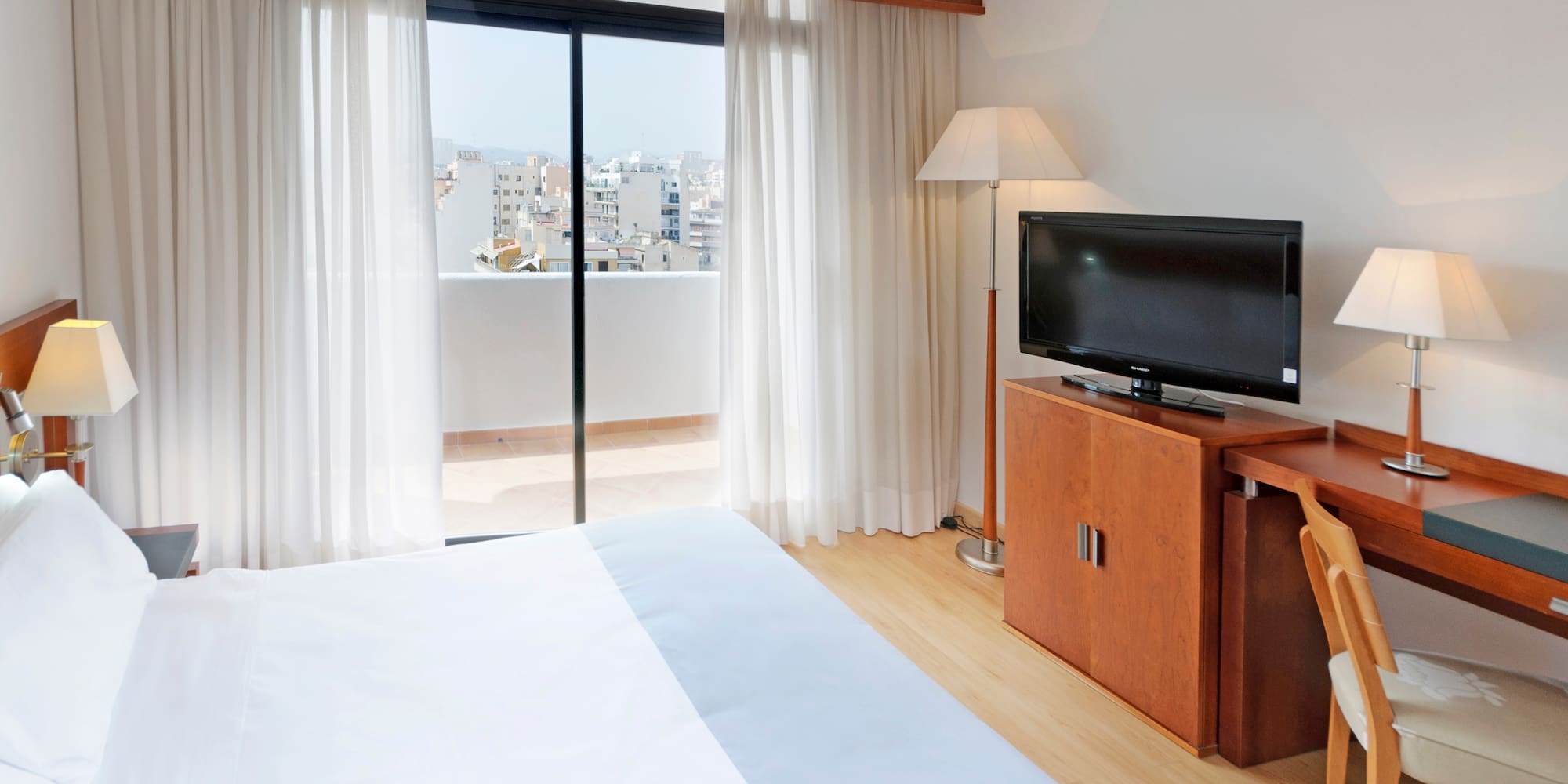 a bedroom with a television and a window