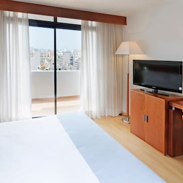 a bedroom with a television and a window